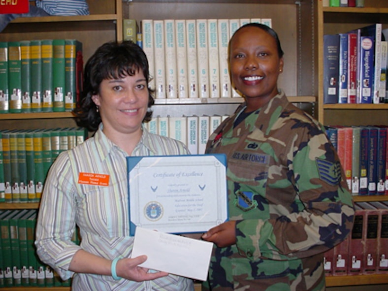 Madison Middle School Deaf Education teacher Sharon Arnold accepts a $200 contribution from Tech. Sgt. Yolanda Hands on behalf of the Dyess 56 Club May 10 in honor of 7th Bomb Wing Command Chief Master Sgt. Paul Wheeler, who recently accepted a year-long tour as command chief of the  332nd Air Expeditionary Wing in Balad, Iraq. Because Chief Wheeler's parents are both deaf, Dyess E-5s and E-6s were moved to collect the money and donate it to a cause close to his heart as a "goodbye" gift. (Photo provided by Sharon Arnold)