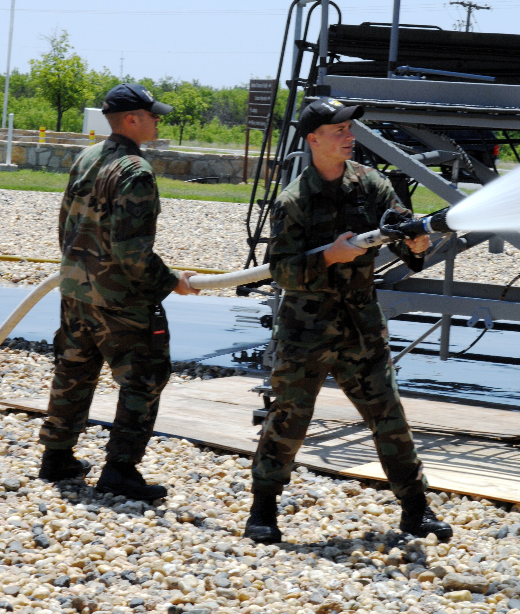Dyess Air Force Base, Texas- Staff Sergeant Michael Rolirad (left) and Senior Airman Richard Hinson (right) from the Component Maintenance Squadron hose down The Star of Abilene to help in the refurbishing process May 16. "The Star of Abilene" was the first production B-1B delivered to the Air Force and is now on permanent display at the front gate of Dyess AFB. (U.S. Air Force photo by Airman Jennifer Romig)