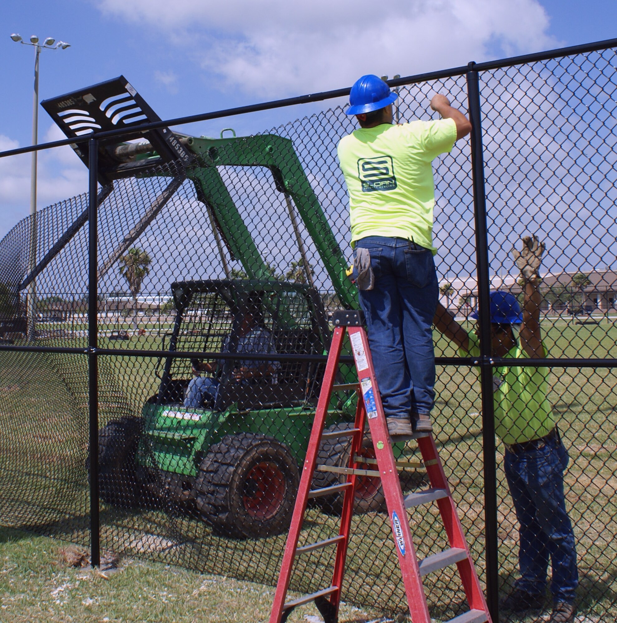 Workers install a new fence at the Homestead Air Reserve Base softball field.  The completed project will extend the area of the playing field by approximately 30 feet.  (U.S. Air Force photo/Jake Shaw)