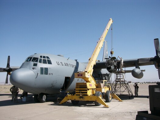 Maintenance repair teams from Bagram Air Base, Afghanistan and the 379th Air Expeditionary Wing change the engine of a C-130 under harsh conditions in an abandoned airstrip just outside of Shindand, Afghanistan. Security forces Airmen stood watch for about 50 hours to ensure the aircraft and crew were safe from harm while on the ground. 