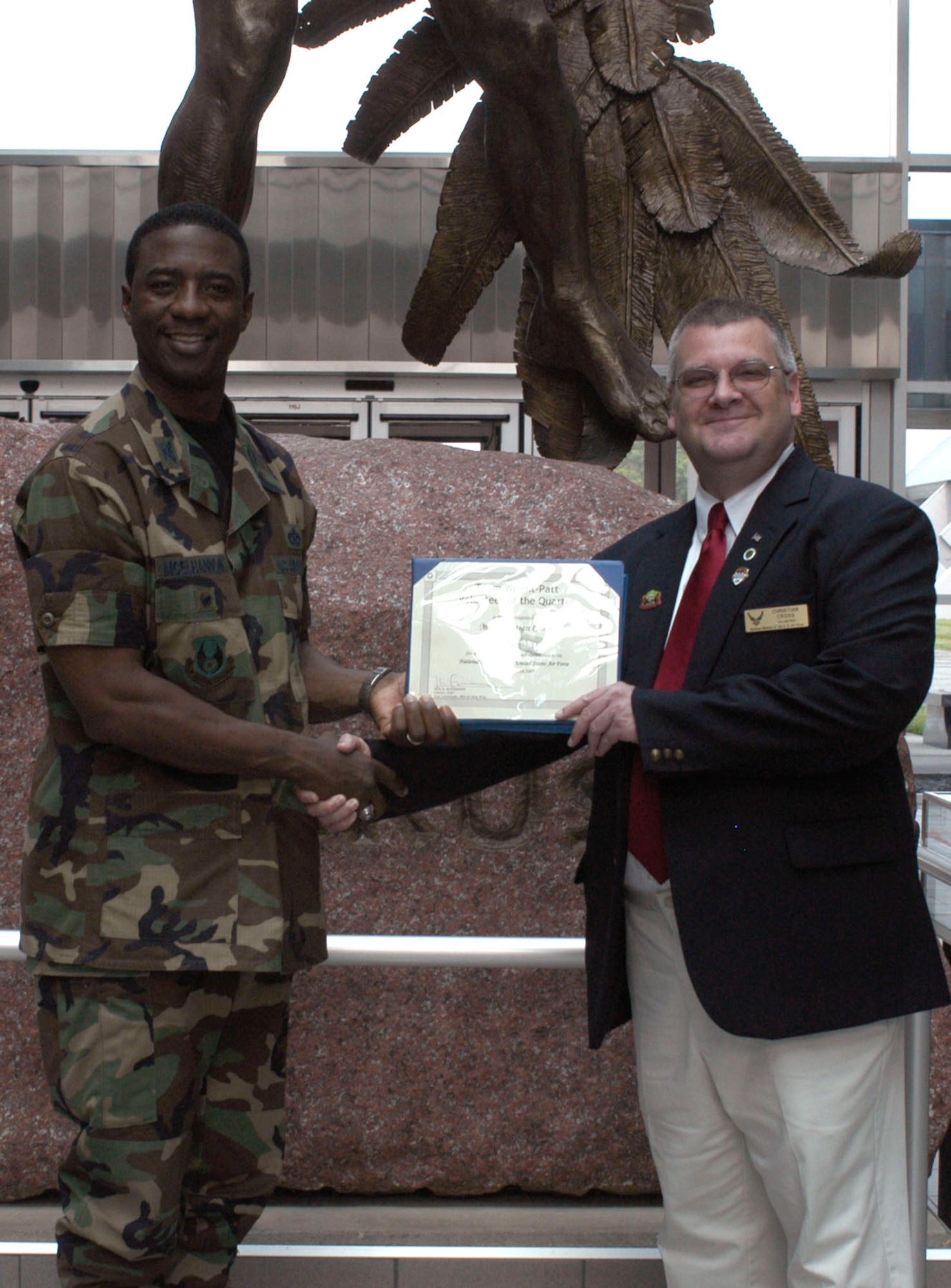 DAYTON, Ohio -- Christian Cross (right), a volunteer at the National Museum of the United States Air Force, accepts the Team Wright-Patt Volunteer of the Quarter award from 88th Air Base Wing Vice Commander Col. Neal B. McElhannon. (U.S. Air Force photo)