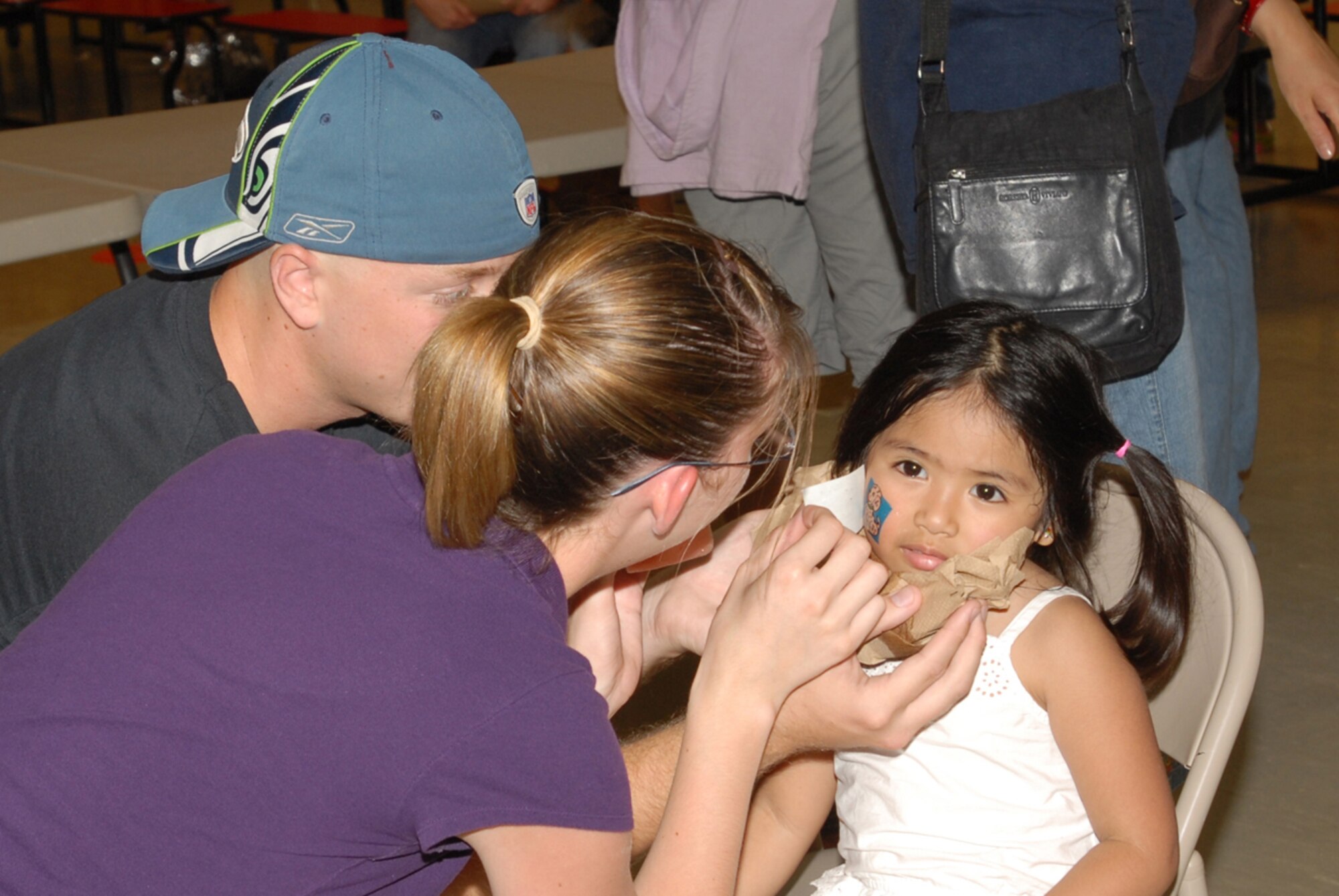 Airman 1st Class Kristy Ramsey (right), 18th Medical Support Squadron, and A1C Jack Ramsey, 18th Communications Squadron, put a fake tattoo on a little girl during the Bob Hope Elementary School end of the year carnival May 24 at Kadena Air Base, Japan.
(U.S. Air Force/Airman 1st Class Kasey Zickmund)