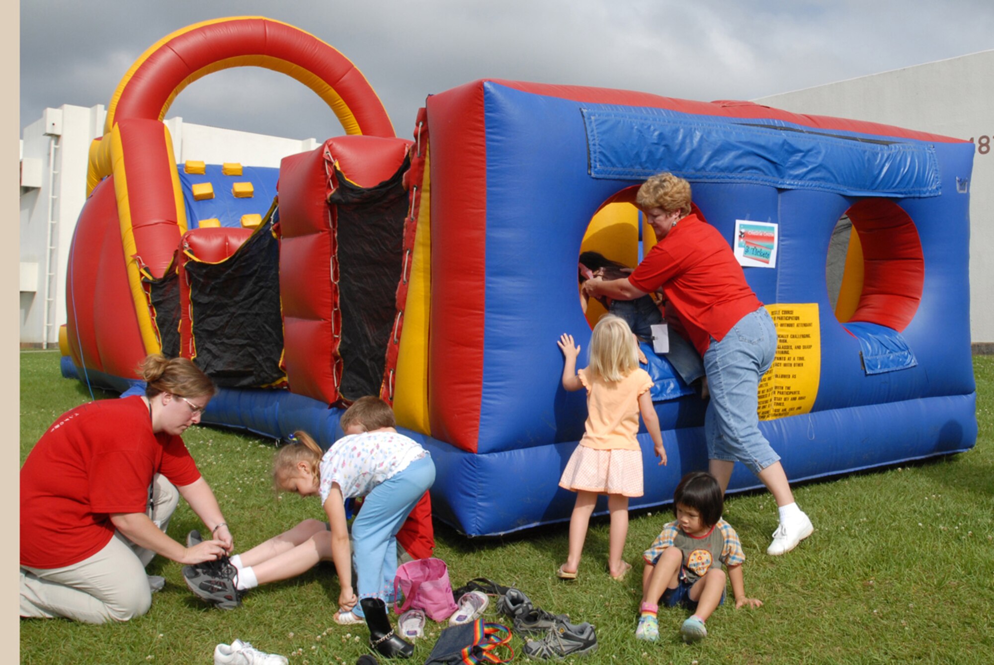 Julianne Miles (right), 1st grade teacher at Bob Hope Elementary School, helps some children into an inflatable obstacle course during the Bob Hope Elementary School end of the year carnival May 24 at Kadena Air Base, Japan.
(U.S. Air Force/Airman 1st Class Kasey Zickmund)
