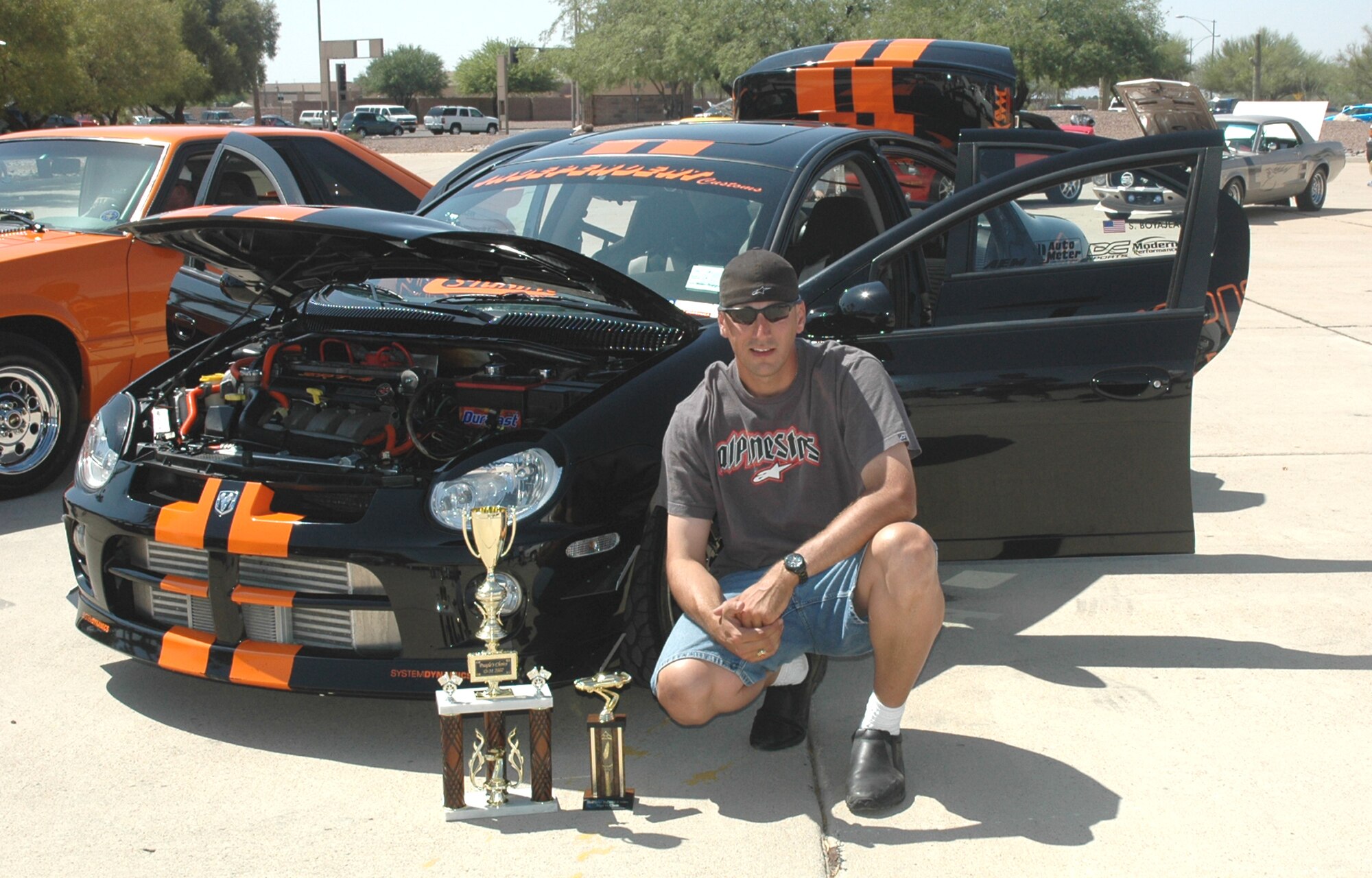 Army Sgt. Sheldon Boyajean, a military policeman at Fort Huachuca, Ariz., poses in front of his 2004 Dodge SRT 4, which won the “People’s Choice” award at the Armed Forces Day Car and Motorcycle Show here May 19. (U.S. Air Force photo/Airman Jamie Coggan)