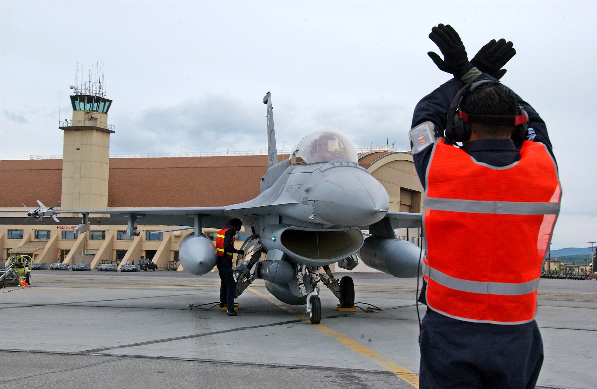 A Republic of Singapore Air Force crew chief marshals a Singapore F-16 after landing at Eielson Air Force Base, Alaska, May 30 for Red Flag-Alaska 07-2. The series of Pacific Air Forces commander-directed field training exercises for U.S. forces provides joint offensive counter-air, interdiction, close-air support and large-force employment training in a simulated combat environment. (U.S. Air Force photo/Senior Airman Justin Weaver)
