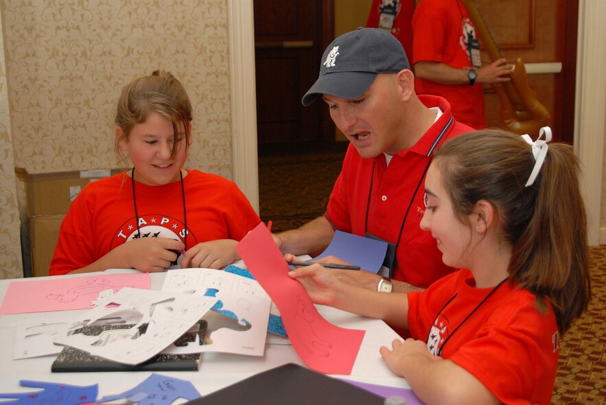 Tech. Sgt. Phillip Shaw, an Air Force Honor Guard member, talks with two attendees of the Tragedy Assistance Program for Survivors.  Held over Memorial Day weekend, TAPS is a three-day camp children and family members who have lost a loved one in military service can attend that aims to help teach families how to grieve, as well as share their stories and make friends who share their loss.