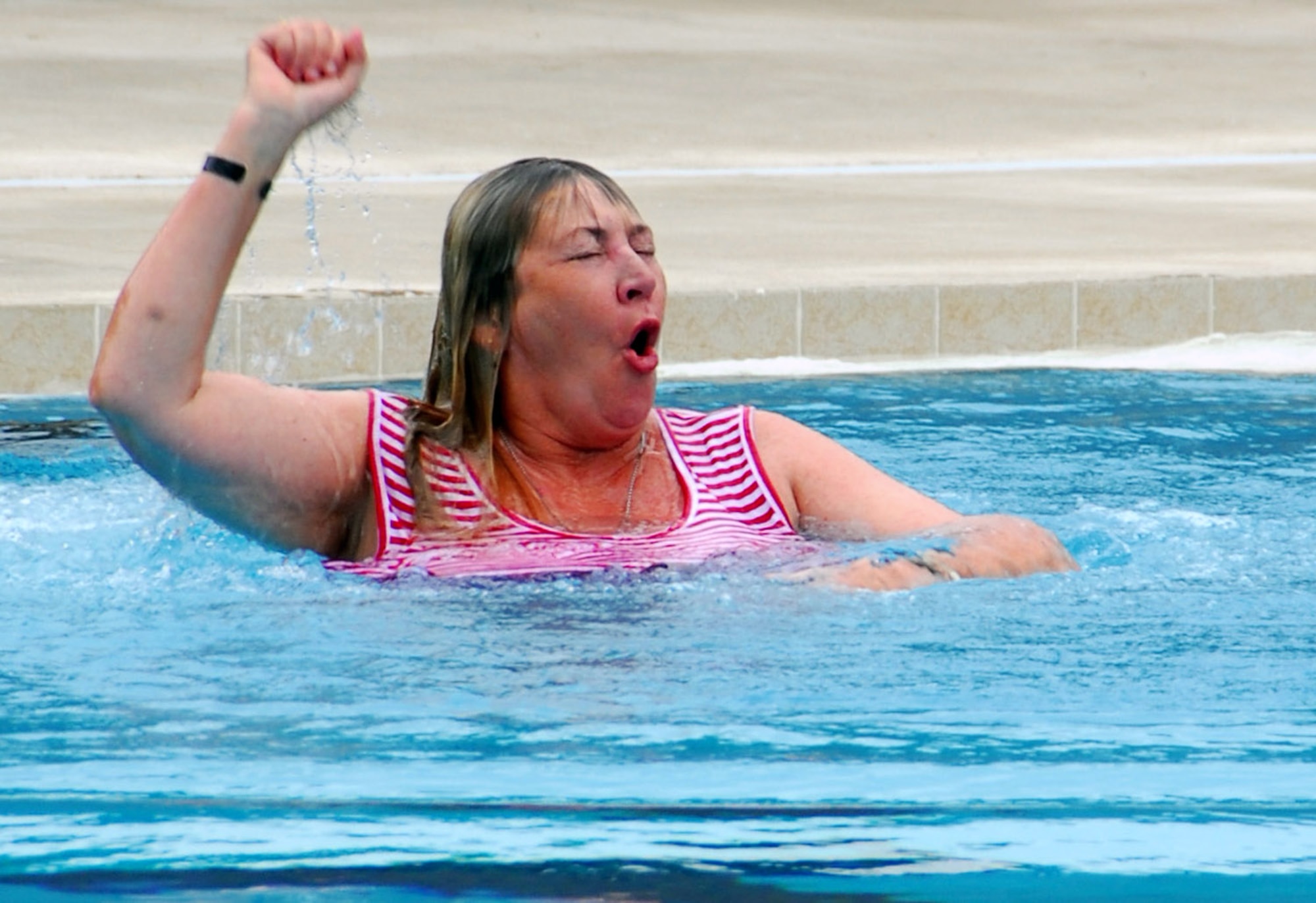 Debra Bastain, the mother of Capt. Derek Argel, a fallen Air Force special tactics officer, takes an impromptu dive into the pool at the aquatics training facility dedicated in Captain Argel's memory May 30 at Hurlburt Field, Fla. Captain Argel, who died in the crash of an Iraqi air force aircraft on Memorial Day 2005, was captain of the water polo team while a cadet at the U.S. Air Force Academy. (U.S. Air Force photo/Chief Master Sgt. Gary Emery)