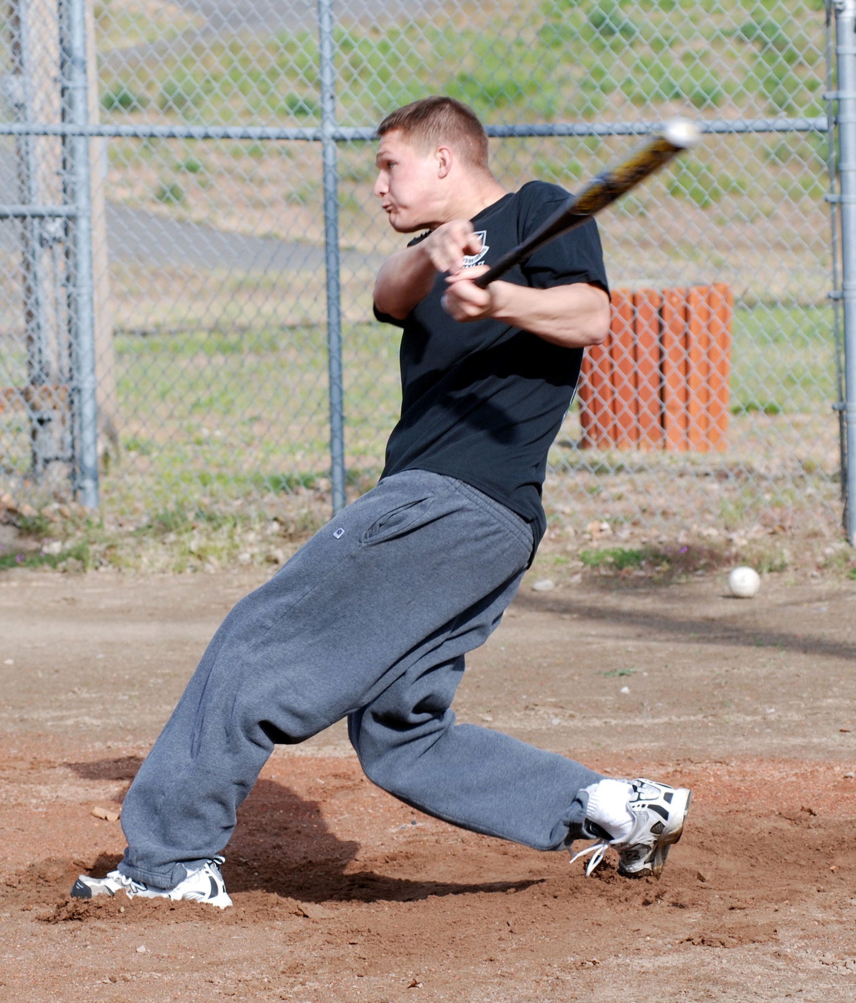 FAIRCHILD AIR FORCE BASE, Wash. – Senior Airman Travis Elmore, 92nd Security Forces Squadron patrolman, powers a ball over the fence in the outfield during practice May 24. Airman Elmore is a member of the security forces squadron intramural softball team. The season begins June 5. (U.S. Air Force photo/Tech. Sgt. Larry Carpenter)