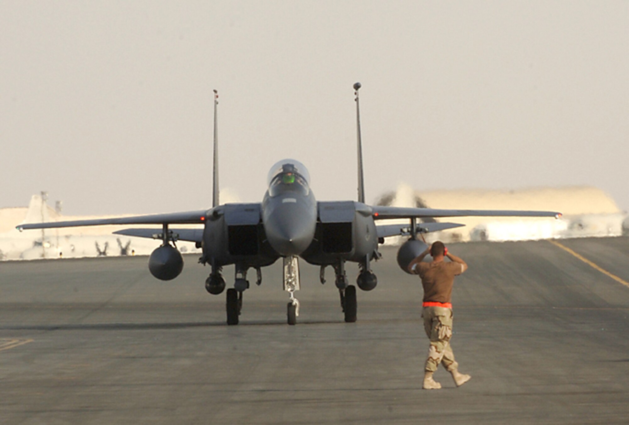 A maintainer marshals a returning Air Force F-15E Strike Eagle at a base in Southwest Asia.  Strike Eagles were part of the 39 close-air-support missions flown for Operation Enduring Freedom May 30.  (U.S. Air Force photo)

