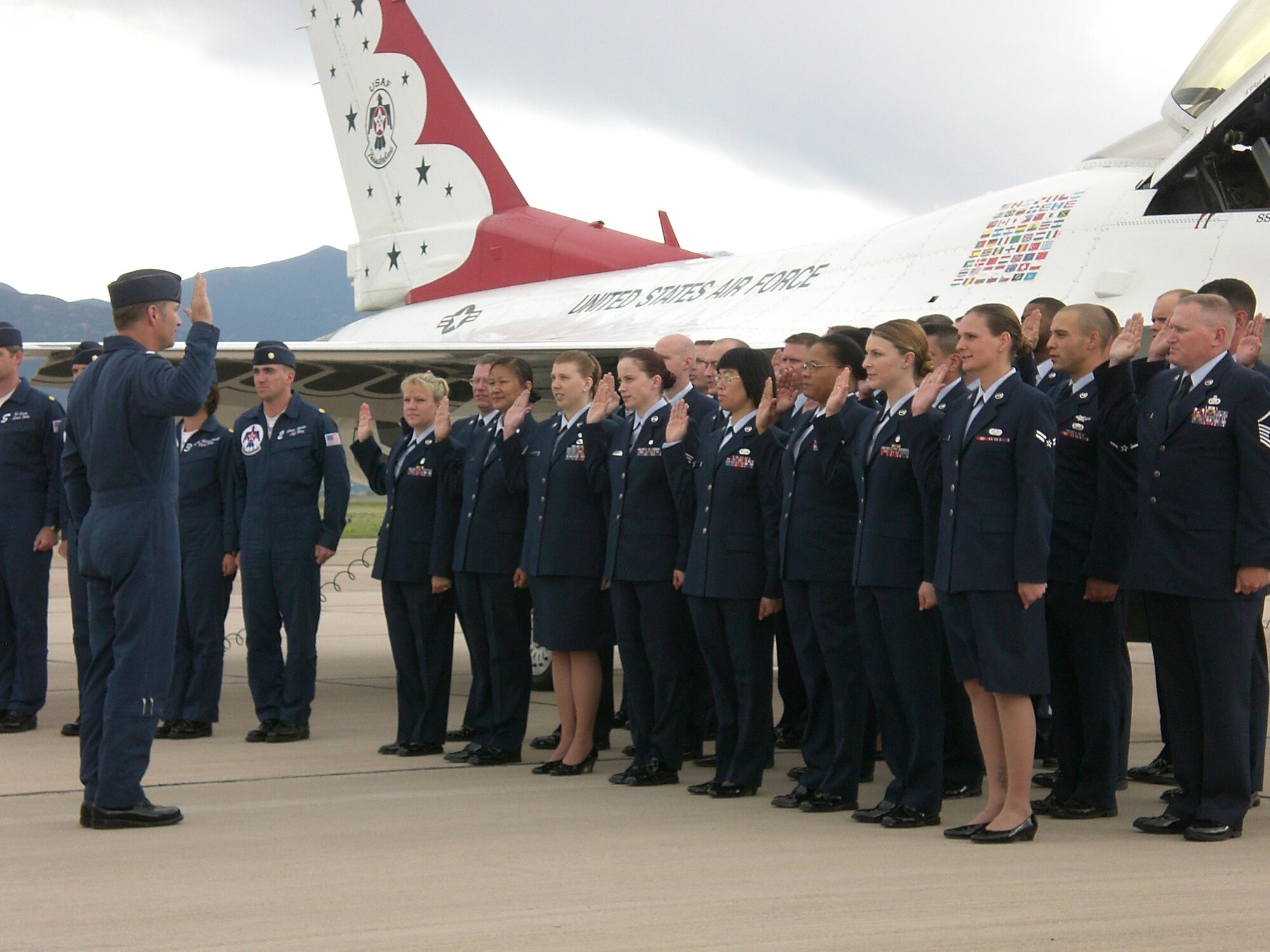 Thunderbirds pilot Lt. Col. Kevin Robbins leads 30 Airmen from Buckley, Shriever and Peterson Air Force Bases, in the oath of enlistment during a re-enlistment ceremony on the Peterson flight line. Twenty Airmen re-enlisted and 10 reaffirmed their oaths during the ceremony May 28. (U.S. Air Force photo by Staff Sgt. Stacey Haga)