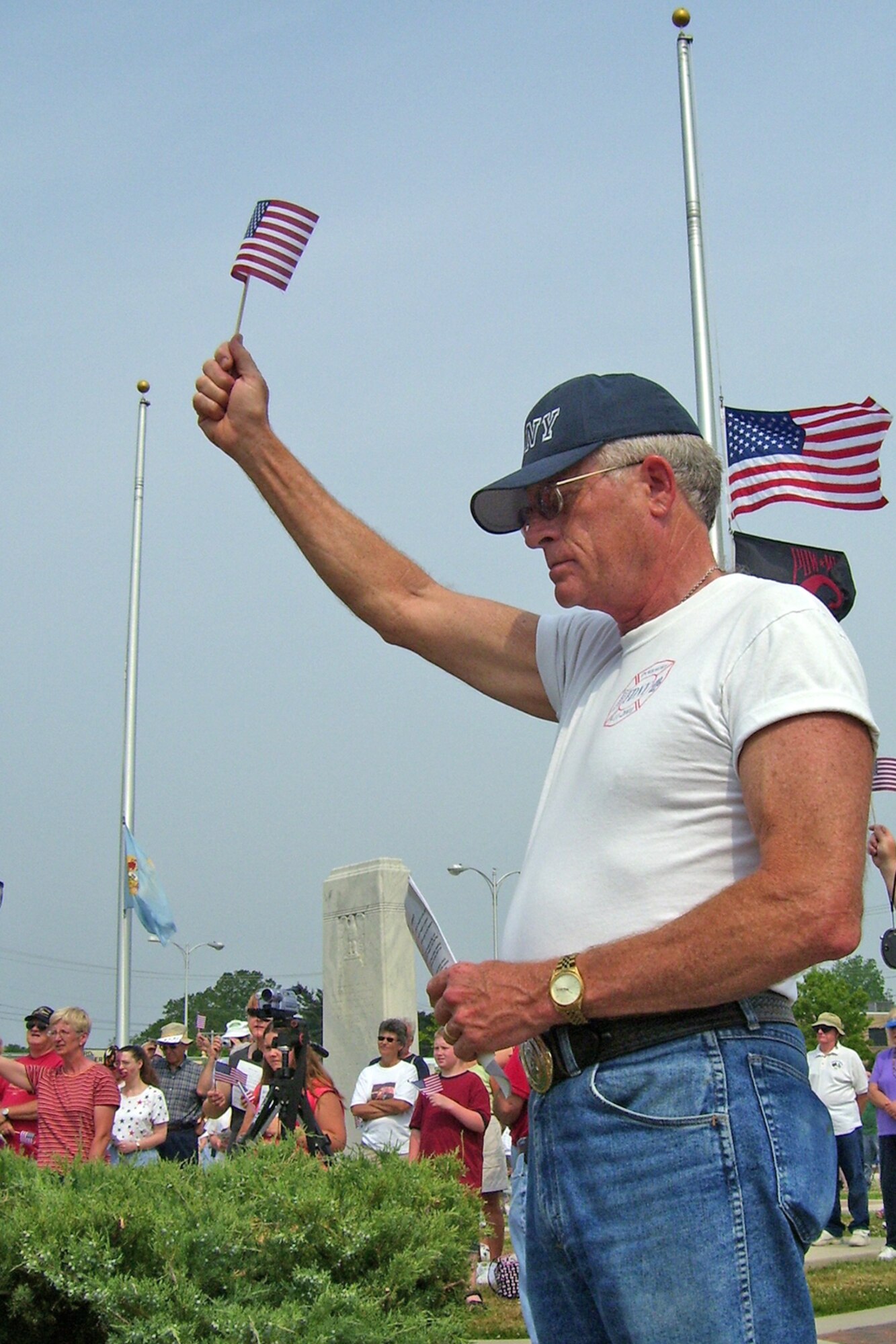 Gary Long waives a miniature American Flag and closes his eyes as 'God Bless the USA,' is sung during a Memorial Day Ceremony and Iraqi / Afghanistan War Memorial Memorial Dedication in Milford, Del. May 28. (U.S. Air Force photo/Tech. Sgt. Kevin Wallace)