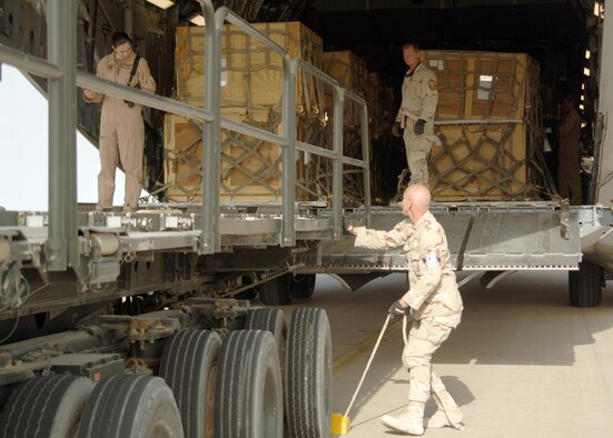 AL ASAD AIR BASE, Iraq — Tech. Sgt. Geoffrey Crowe, front, Cargo Section NCOIC with 438th Aerial Port Flight at Al Asad, and Senior Master Sgt. Tom Luke, back, Day Shift Supervisor with the 438th APF coordinate offload of a Charleston AFB, S.C. C-17 Globemaster III. Since the beginning of AEF 5/6 in January, the 438th's Aerial Porters have processed more than 32,000 passengers, 15,528 tons of cargo, and more than 2,600 aircraft keeping nearly 12,000 personnel off the roads in convoys, undoubtedly saving many lives that might have been lost in improvised explosive devices (IEDs) and Anti-Iraqi forces attacks during over-the-road convoys that have been mitigated through airlift. Both sergeants are deployed from the 76th Aerial Port Squadron, Youngstown Air Reserve Station, Ohio. (U.S. Air Force Photo/Master Sgt. Bryan Ripple)