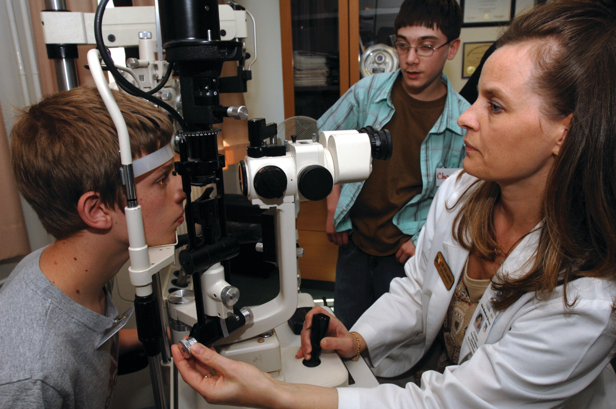 SPANGDAHLEM AIR BASE, GERMANY -- Students from the Spangdahlem Middle School spend time shadowing  Susan Sabers, 52nd Aerospace Medicine Squadron American Red Cross volunteer, at the Optometry Clinic as part of career day May 24. (US Air Force photo/Airman 1st Class Emily Moore)