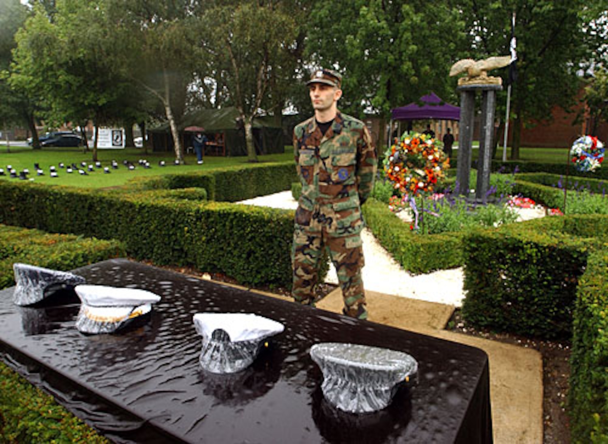 Capt. Constantine Tsoukatos, 100th Aircraft Maintenance Squadron, stands at the POW/MIA memorial during the 24-hour POW/MIA "Reading of the Names" vigil at Royal Air Force Mildenhall, England, Sept.15, 2005. More than 200 base volunteers took turns reading names and standing silent watch over a display of four hats - one from the uniform of each branch of the military which represented the nearly 10,000 service members who have been prisoners of wars or missing in action since the end of World War II. (U.S. Air Force file photo by Staff Sgt. Jeanette Copeland)