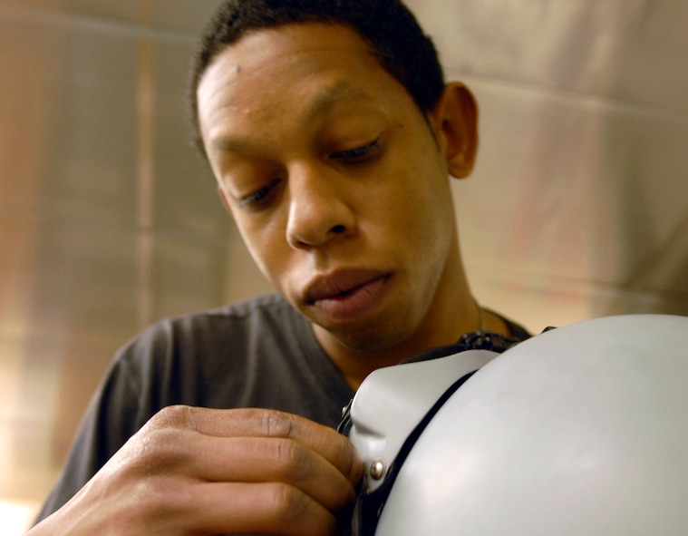 KUNSAN AIR BASE, South Korea -- Senior Airman Cortney Tanner, an aircrew flight equipment journeyman 8th Operation Support Squadron, makes adjustments to Capt. Darin Wetzler's custom visor for his new Joint Helmet Mounted Cueing System Nov. 1 here.  Airman received hands-on training from a Boeing instructor on how to size, fit, inspect and maintain the JHMCS helmet and related sub-systems. (U.S. Air Force photo/Senior Airman Steven R. Doty)