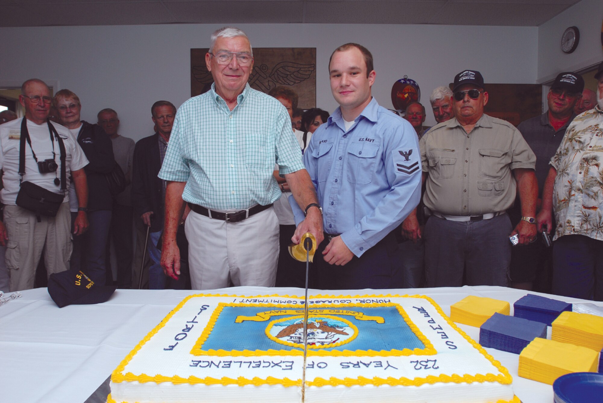 Retired Navy Senior Chief Petty Officer Wilbur House, the oldest Sailor present, and Petty Officer 2nd Class Gabriel Wingard, the youngest Sailor present, cut the Navy birthday cake. (U.S. Air Force photo by Tech. Sgt. Gina O’Bryan)