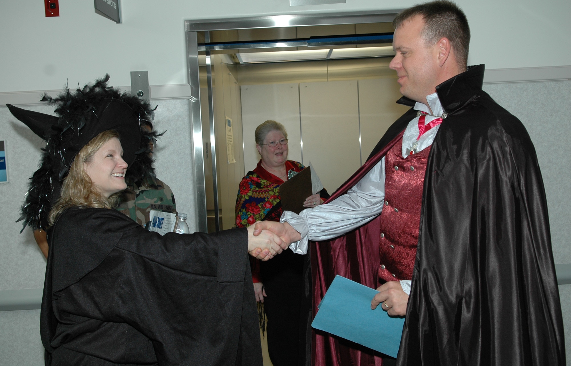 FAIRCHILD AIR FORCE BASE, Wash. -- Lori Sharpy, spouse of Col. Thomas Sharpy, 92nd Air Refueling Wing commander, shakes hands with Tech. Sgt. Nolan Lawson, 92nd Medical Group NCOIC of family health, as she made her way around judging costumes during the medical group’s Halloween costume parade. The winner of the contest was Rhett Norris, a civilian contractor physical therapist with the 92nd MDG with honorable mention going to Senior Airman Nemesio Perez, 92nd MDG optometry technician. The Halloween costume parade provided an opportunity for children throughout base to accomplish some early trick-or-treating throughout the medical group. (U.S. Air Force photo/Tech. Sgt. Larry W. Carpenter Jr.)