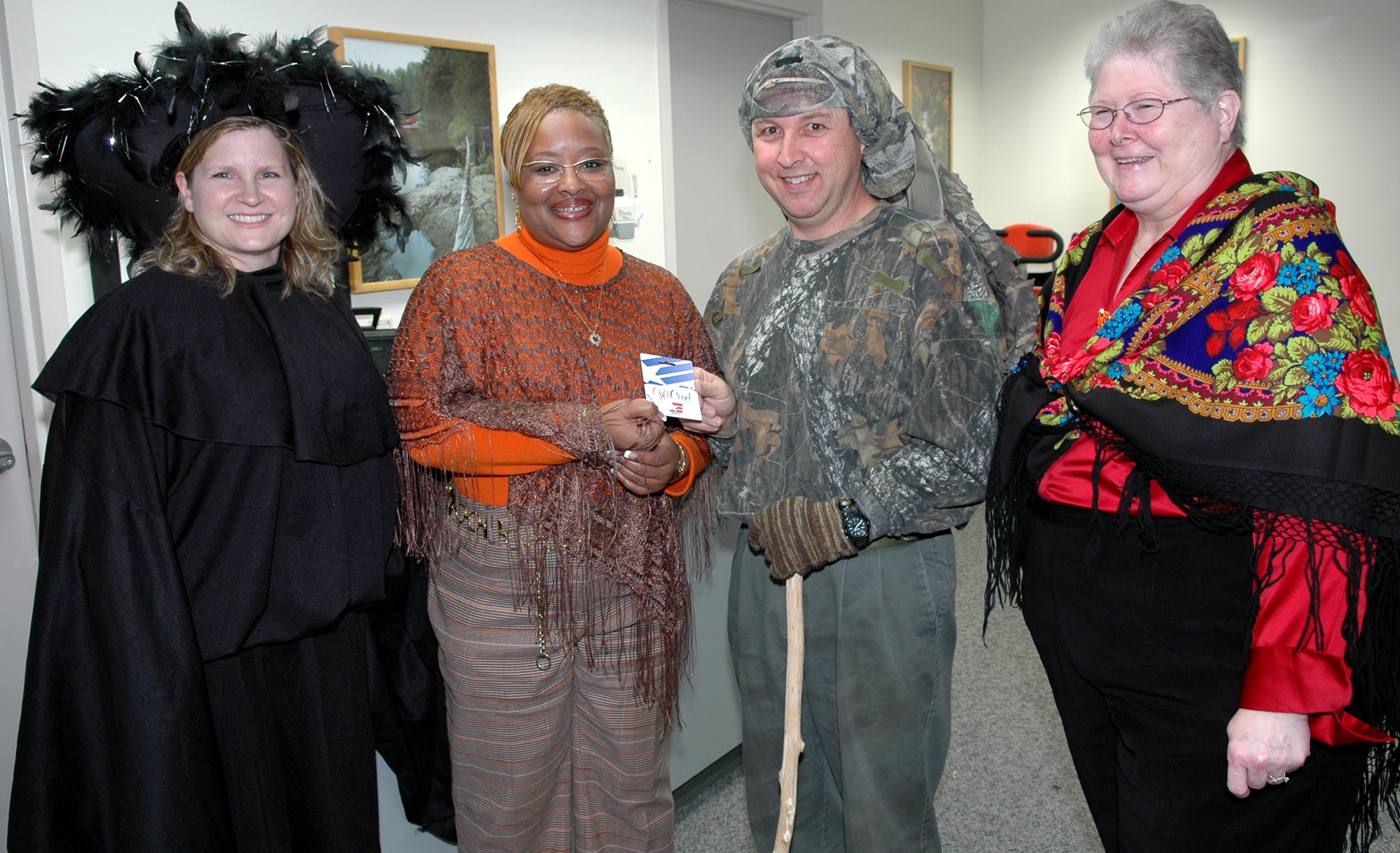 FAIRCHILD AIR FORCE BASE, Wash. -- From left to right, Lori Sharpy, spouse of Col. Thomas Sharpy, 92nd Air Refueling Wing commander; Della Gooding, community readiness consultant at the Airman and Family Readiness Center; Rhett Norris, a civilian contractor physical therapist with the 92nd Medical Group; and Sue Jasper, secretary for the 92nd MDG commander, show their holiday spirit during the medical group’s Halloween costume parade. Mrs. Sharpy, Mrs. Gooding and Mrs. Jasper followed a pre-determined parade route judging costumes and decorations for 20 different offices throughout the medical group. (U.S. Air Force photo/Tech. Sgt. Larry W. Carpenter Jr.)