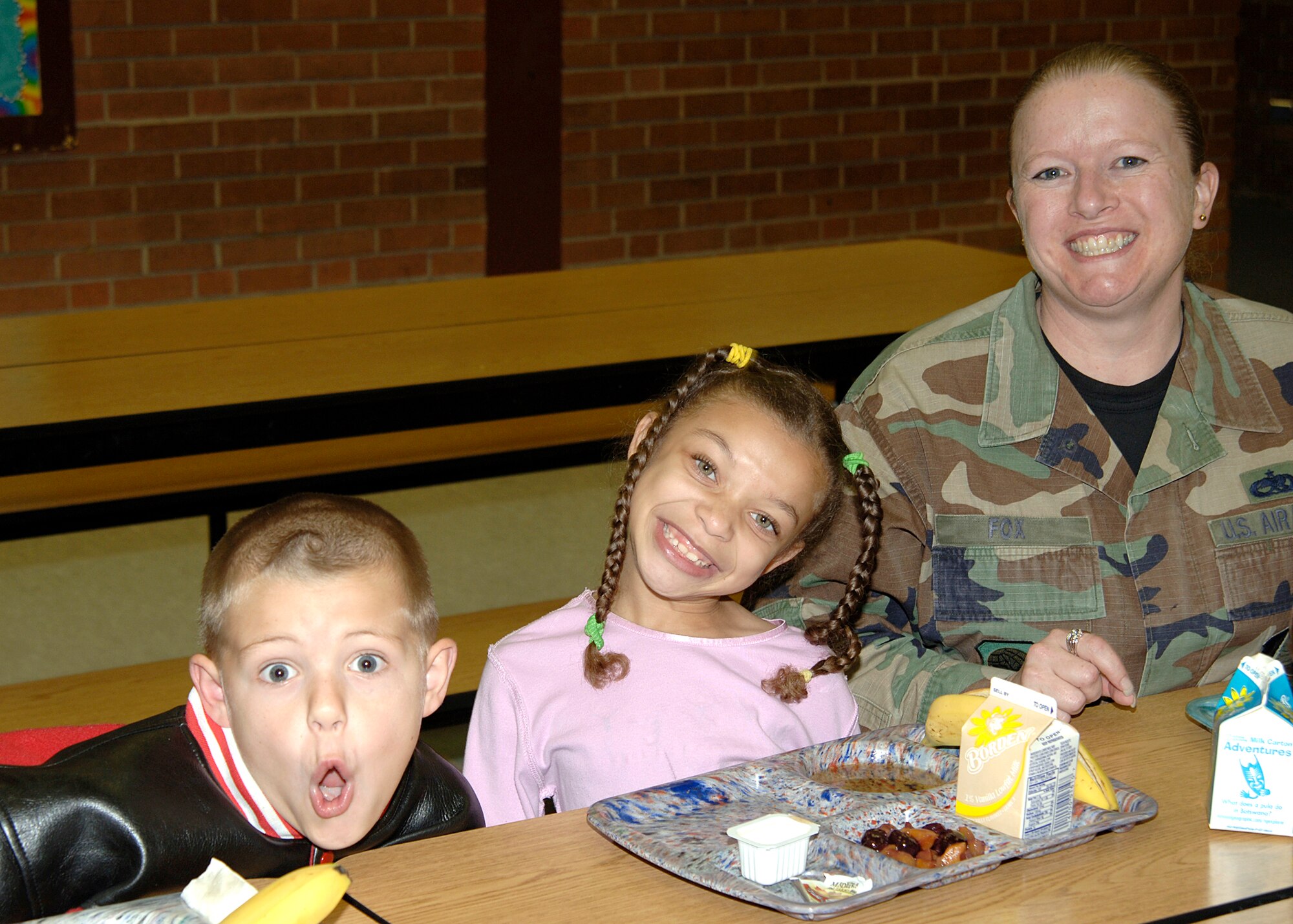 MCCONNELL AIR FORCE BASE, Kan. -- Technical Sergeant Wendi Fox, 22nd Aircraft Maintenance Squadron, poses with two children from the Wineteer Elementary School during their lunch break for the Lunch Buddies program Oct. 25. The Lunch Buddies program is a nationwide program that pairs a caring adult with an elementary students consisting of 1st and 2nd graders, McConnell Air Force Base personnel volunteer to participate in this program every Thursday.  (Photo by Airman 1st Class Justin Shelton)