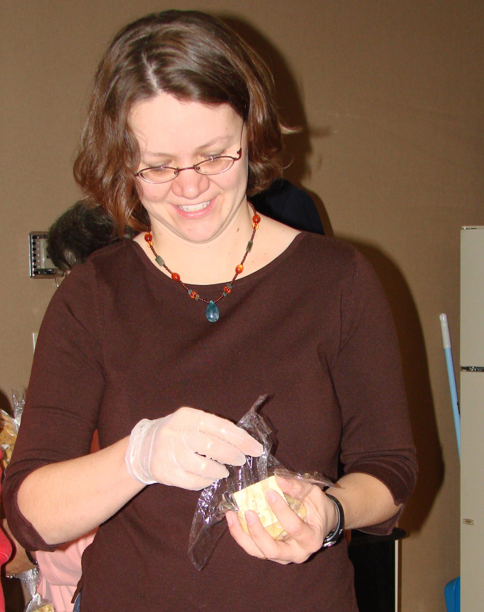 Lara Nash, wife of Chaplain (Capt.) Zachary Nash, Protestant chaplain, packages cookies to place in Operation Cookie Cutter care packages Nov. 1 at the Airman and Family Readiness Center. (U.S. Air Force photo by Tech. Sgt. Mary Davis)
