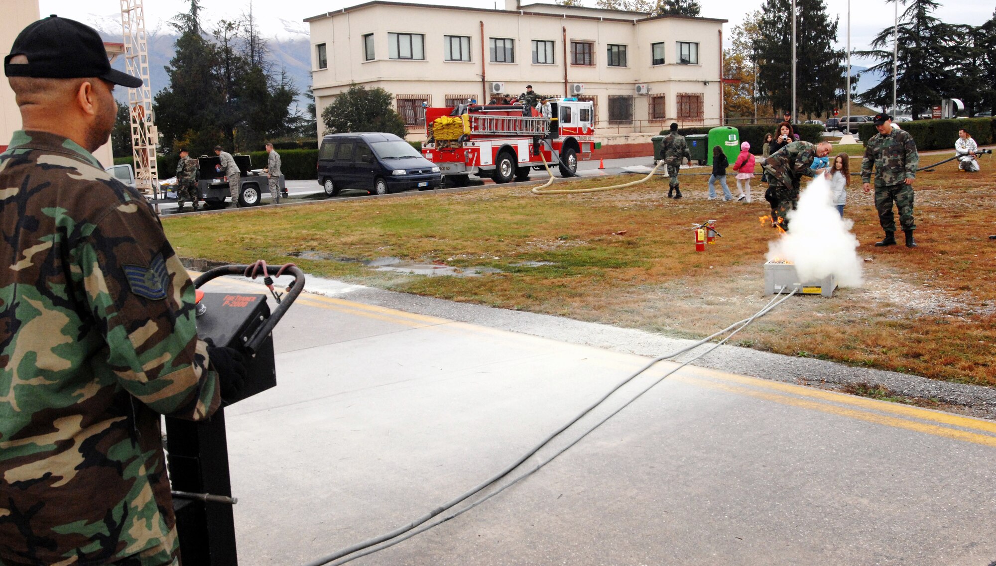 31st Civil Engineer Squadron firefighters help 2nd graders learn how to use a fire extinguisher during a children's deployment day Oct. 24 at Aviano Air Base, Italy. (U.S. Air Force photo/Airman 1st Class Nathan Doza)