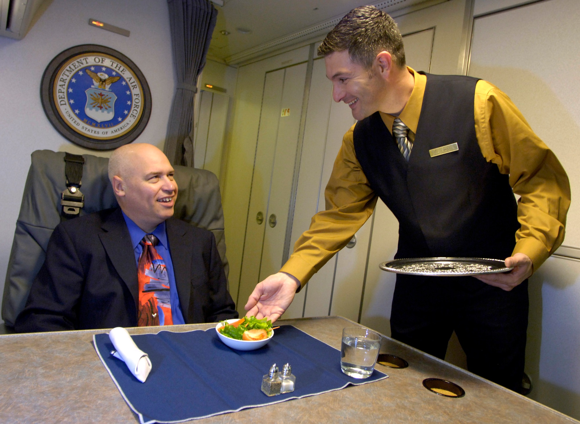 Tech. Sgt. Pete Kana serves a salad course Oct. 31 in the state room of a C-32A aircraft. Sergeant Kana is a special air mission flight attendant with the 89th Airlift Wing's 1st Airlift Squadron, Andrews Air Force Base, Md. Though they prepare and serve food and beverages, the top priority of Air Force flight attendants are to ensure the safety of passengers and other crew members on board their aircraft. (U.S. Air Force photo/Master Sgt. Jim Varhegyi)