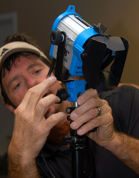 Scott Killian sets up dramatic lighting for an interview with Lt. Col. Kurt Kuntzelman during a media visit Oct. 30. Mr. Killian was part of an Actuality Productions film crew that visited the base to tape a segment on GPS for the History Channel TV series "Modern Marvels." The segment will be part of an episode scheduled to air Feb. 14, 2008. Colonel Kuntzelman is commander of the 2nd Space Operations Squadron here. (U.S. Air Force photo/Staff Sgt. Don Branum) 