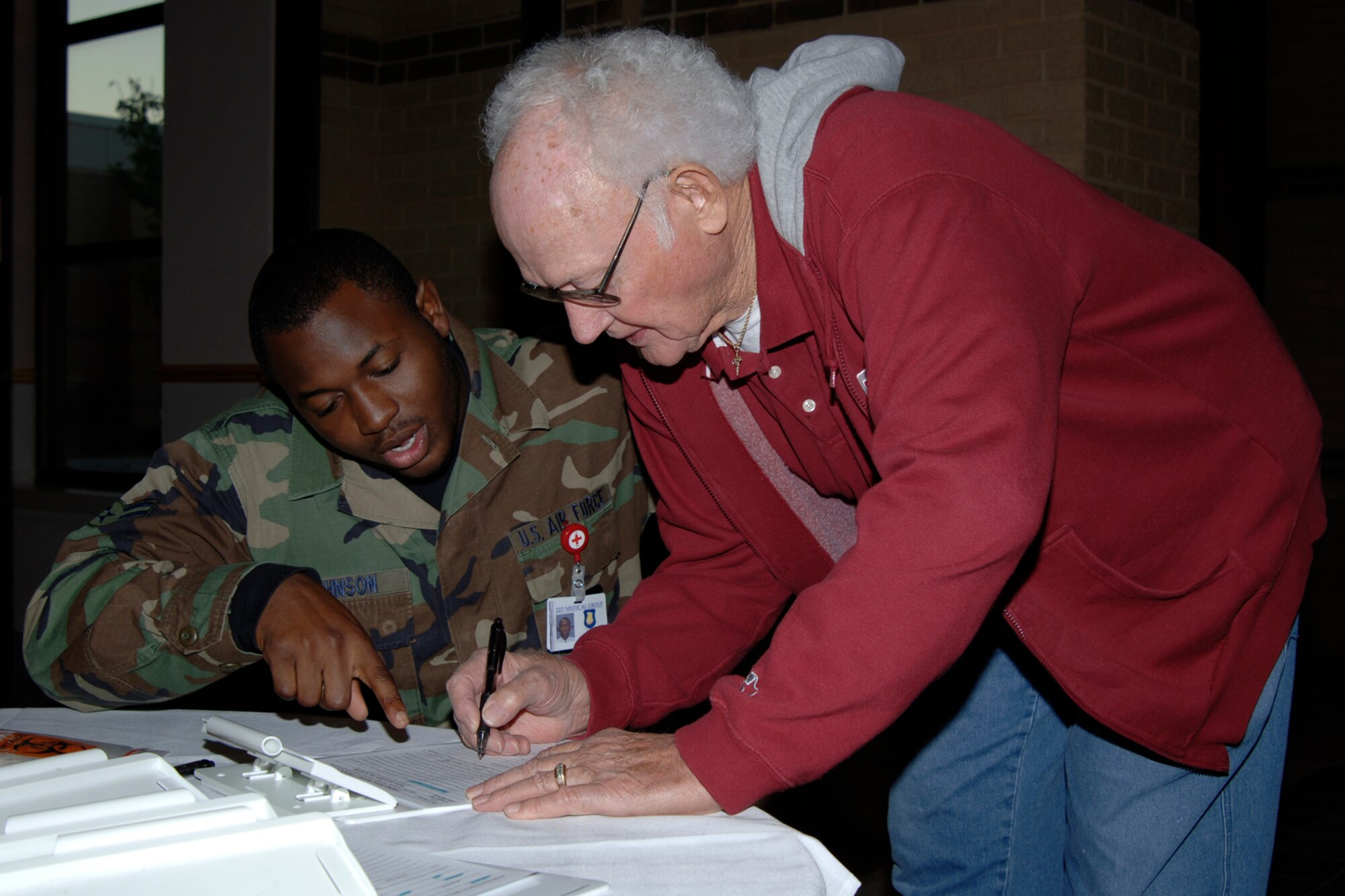 MCCONNELL AIR FORCE BASE, Kan. -- Airman 1st Class Terron Johnson, 22nd  Aero Medical Dental Squadron, helps Retired Master Sergeant Loy Eary sign in for the Annual Retiree Appreciation Day held at the Robert J. Dole Community Center, Oct. 27. Annual Retiree Appreciation Day offers retirees a chance to discuss issues that affect them and hear current topics about the Air Force. Retirees also where able to get information on health updates, finances and volunteer opportunities.  (Photo by Airman 1st Class Roy Lynch)