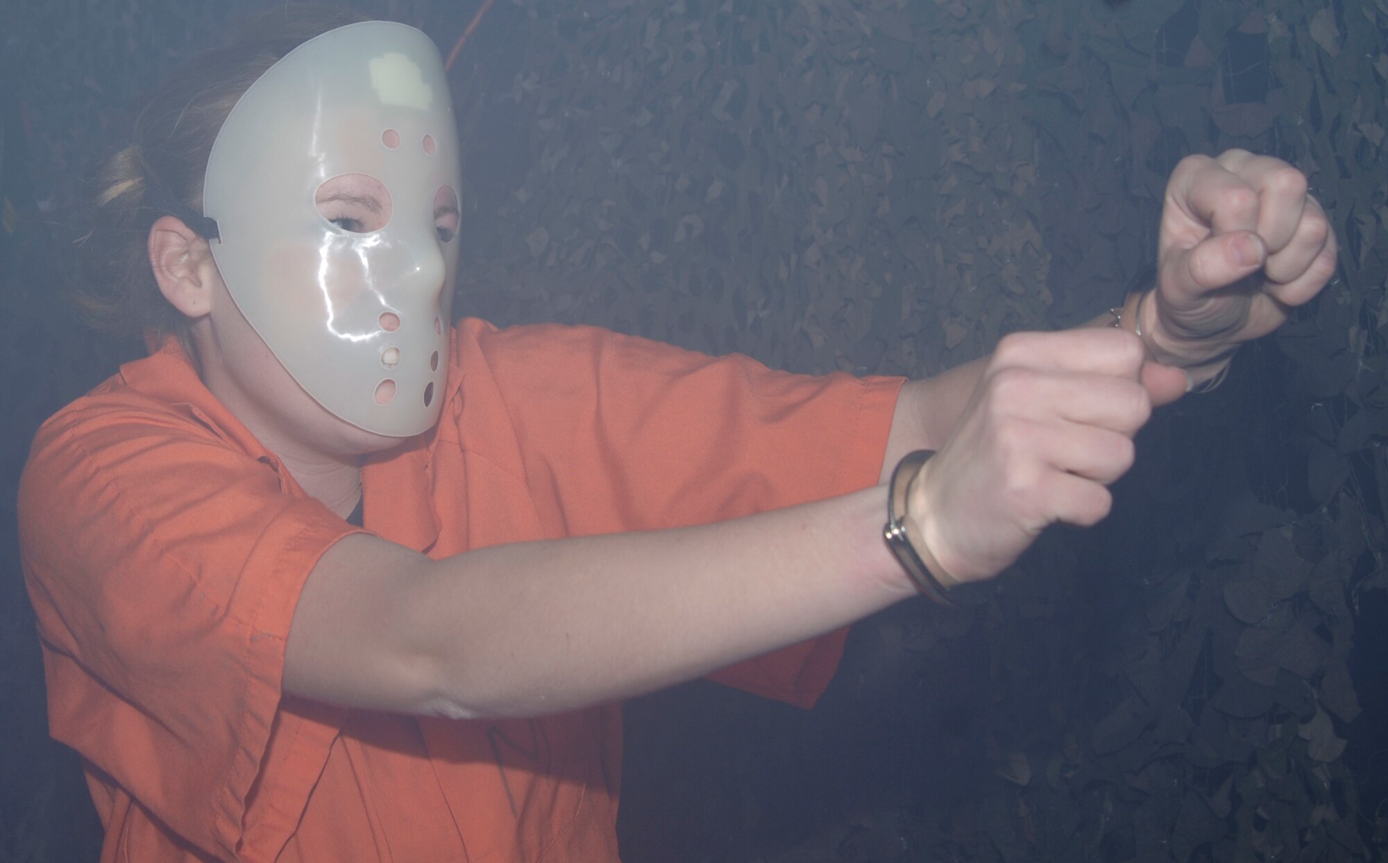 MCCONNELL AIR FORCE BASE, Kan. -- Airman 1st Class Kristen Babicki, 22nd Medical Operation Squadron, pretends to be an escaped convict at a Haunted Halloween House at the Defense Reutilization and Marketing Office warehouse, Oct. 30, sponsored by Outdoor Recreation. Team McConnell members lurked in the fog around creepy corners to find volunteers dressed in scary costumes.  (Photo by Airman 1st Class Roy Lynch) 