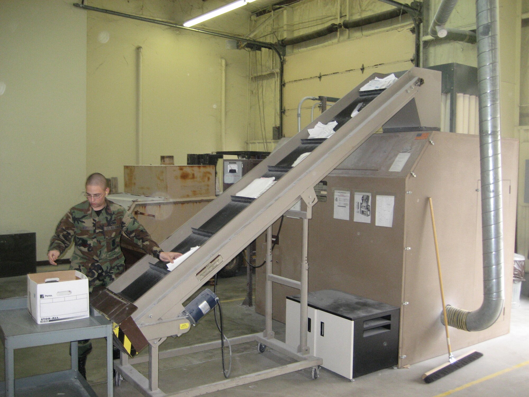 WHITEMAN AIR FORCE BASE, Mo. -- Airman 1st Class Jonathon Crist, 509th Security Forces Squadron, assists with destroying documents in a disintegrator Oct 26. This industrial shredding machine is approved for obliterating top-secret material. (U.S. Air Force photo/Maj. Joe DellaVedova)