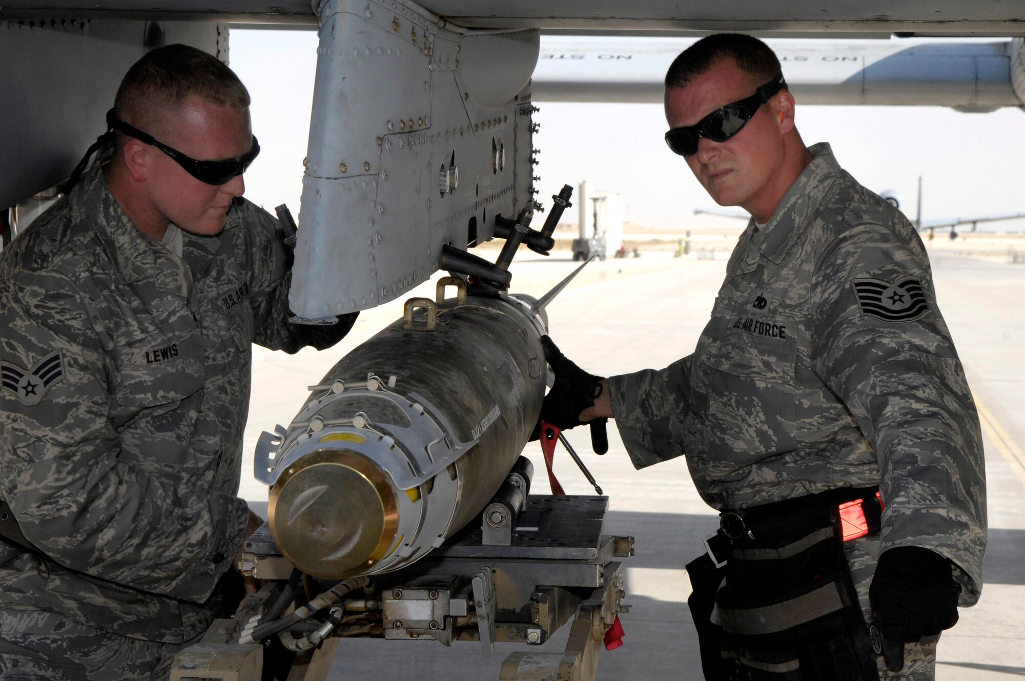 Senior Airman Larry Lewis (left) and Tech. Sgt. David Rey remove a bomb from an A-10 Thunderbolt II.  The weapons loaders are deployed to Southwest Asia from the Maryland Air National Guard's 175th Wing.  The A-10, with excellent maneuverability and accurate weapons delivery, provide vital close-air support to coalition troops on the ground.  (U.S. Air Force official photo by Staff Sgt Angelique Perez)