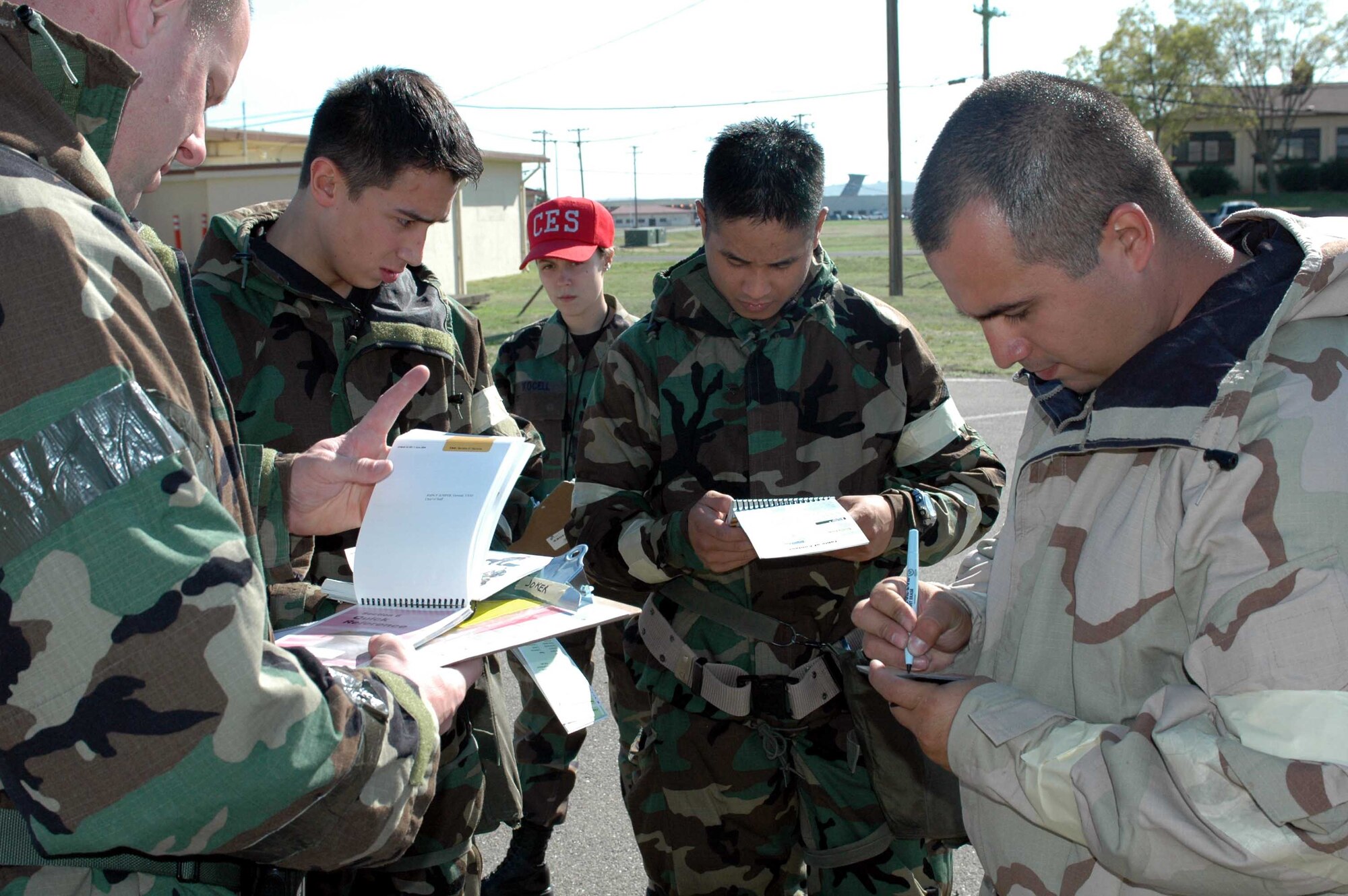 Chemical, Biological, Radiological, Nuclear, Explosives Defense Survival Skills training course students refer to their Airman's Manual during CBRNE training as Airman 1st Class Tasha Kocell, (CES hat), course instructor, looks on. Course instructors instituted new and improved changes to the class format in order to enhance and standardize training throughout the Air Force. (U.S. Air Force photo/Staff Sgt. Candy Knight)
 
