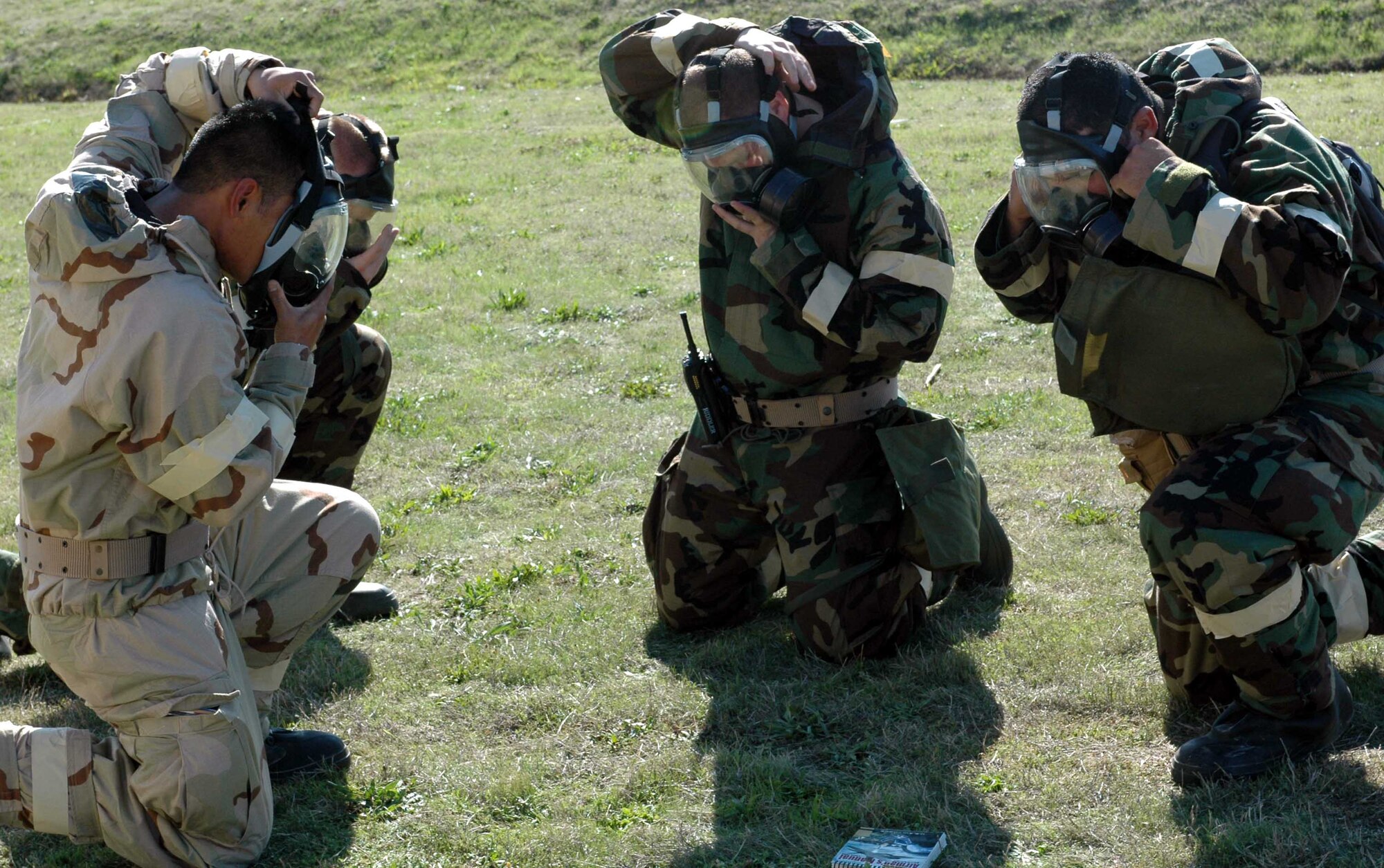 Members of "Team Riddler" don their gas mask during a mock gas attack as part of the Chemical, Biological, Radiological, Nuclear, Explosives Defense Survival Skills training course. Recent improvements to the course requires students to demonstrate the proper procedures before, during and after an enemy attack. (U.S. Air Force photo/Staff Sgt. Candy Knight)