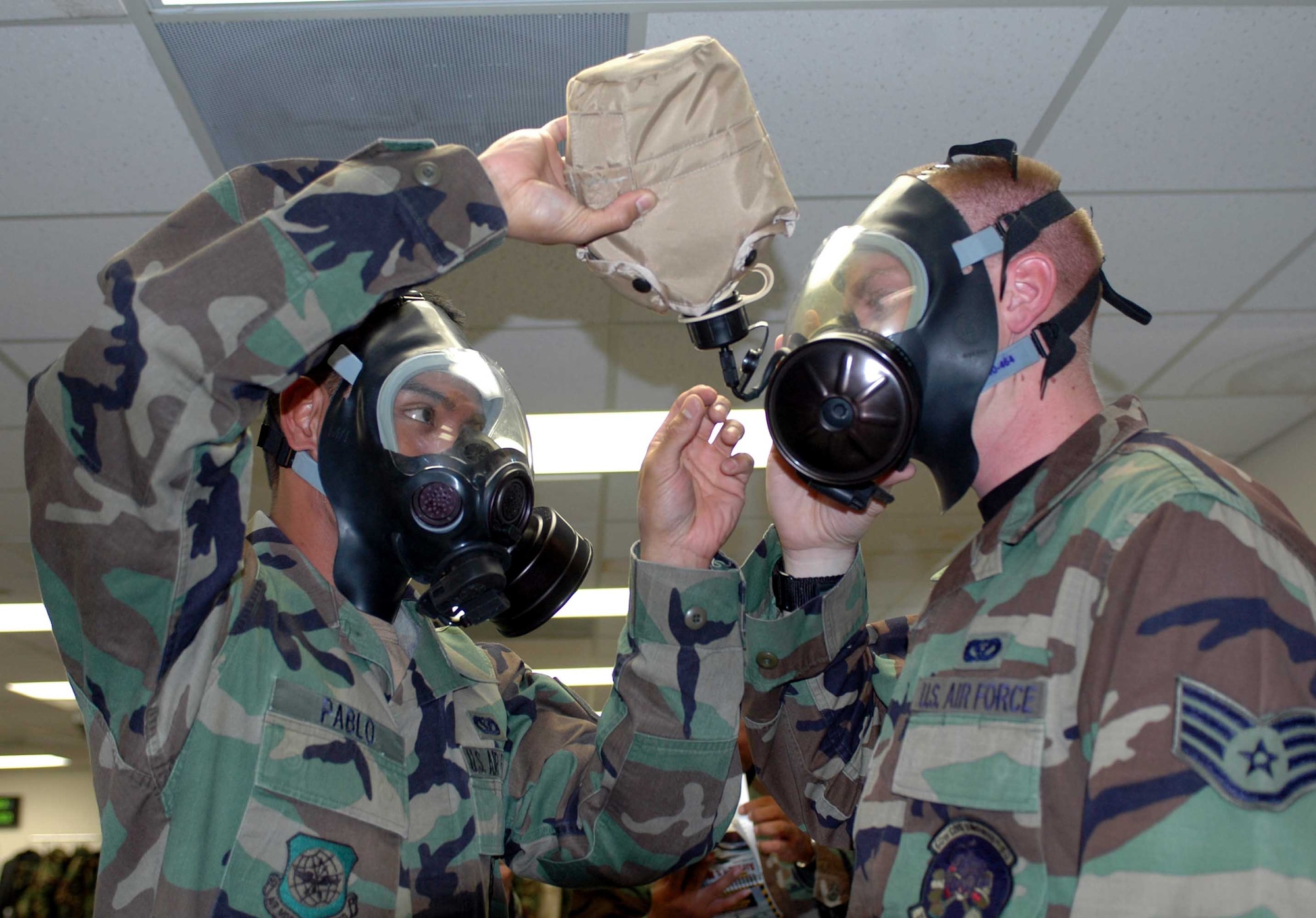 Staff Sgt. Alvin Pablo, (left), 60th Civil Engineer Squadron, helps his wingman, Staff Sgt. Harold Longnickel, 60th CES, rehydrate during a recent Chemical, Biological, Radiological, Nuclear, Explosives Defense Survival Skills training class. Course instructors instituted new and improved changes to the class format in order to enhance and standardize training throughout the Air Force. (U.S. Air Force photo/Staff Sgt. Candy Knight)