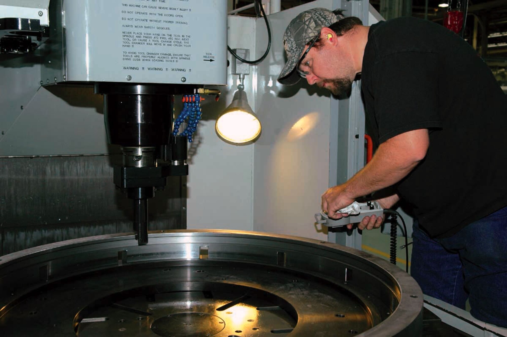 John Gee prepares a vertical turning center machine to bore the inside diameter on a fixture that holds aircraft parts. Mr. Gee is a toolmaker with the 547th Propulsion Maintenance Squadron. (U.S. Air Force photo/Ron Mullan)