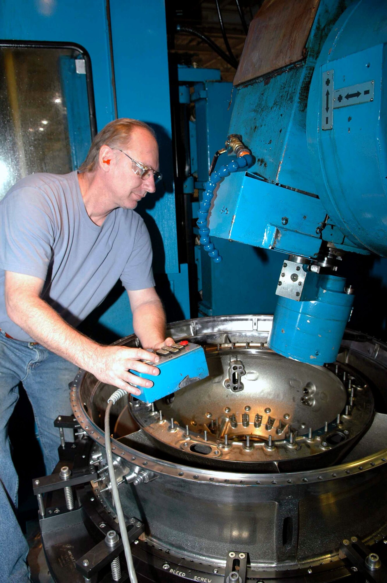 Mike Kraus makes adjustments on a five-axis milling machine prior to working on an F119 intermediate compressor. Mr. Kraus is a machinist with the 547th Propulsion Maintenance Squadron. (U.S. Air Force photo/Ron Mullan)