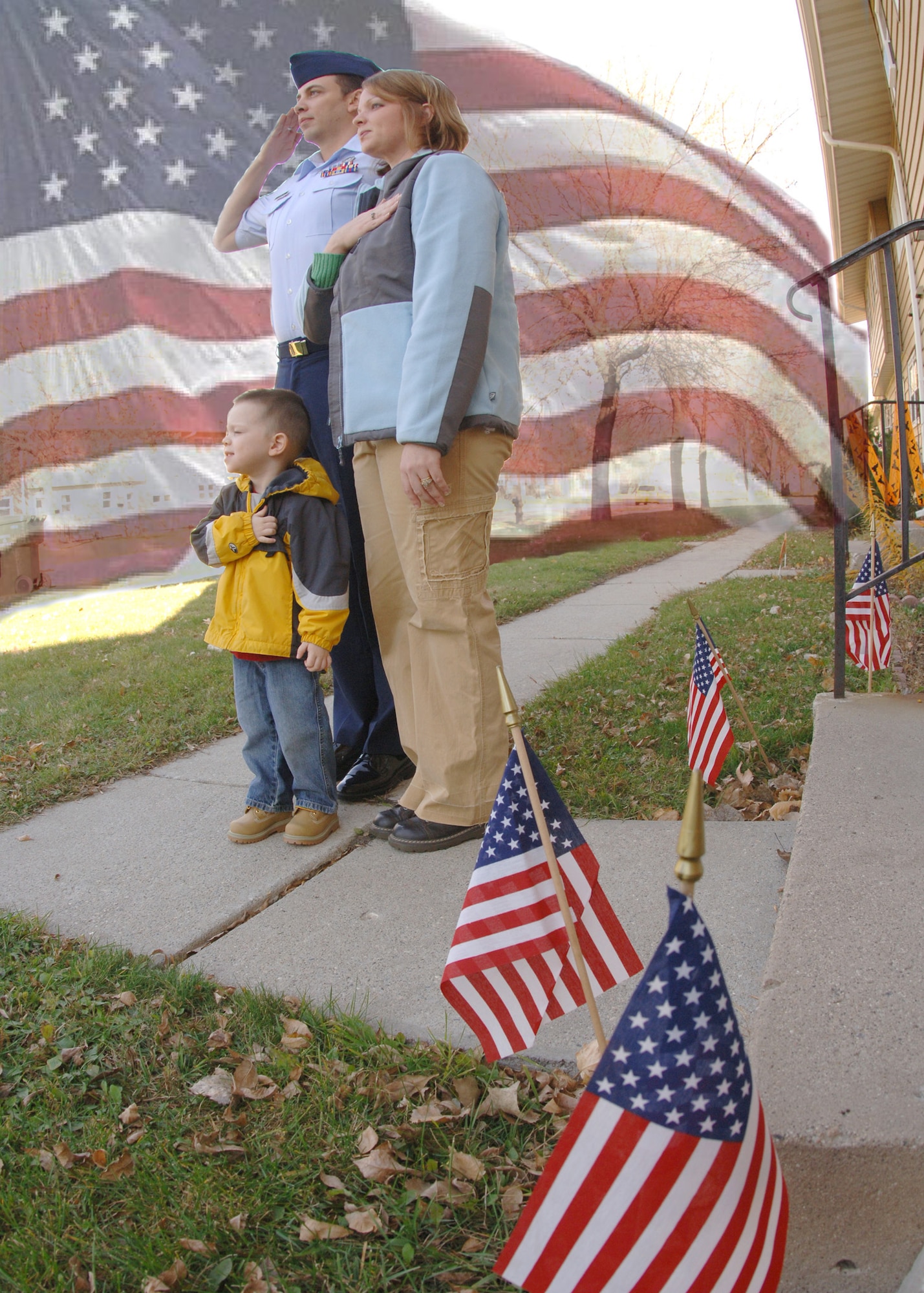 Senior Airman James Croxon, his wife Angie and son Jake, stand and pay respects to the flag during a retreat ceremony at Grand Forks Air Force Base, N.D.  It is important for all military members and dependents to understand their responsibilites during the playing of reveille and retreat on a military installation. (Photo illustration by Senior Airman  Chad Kellum)