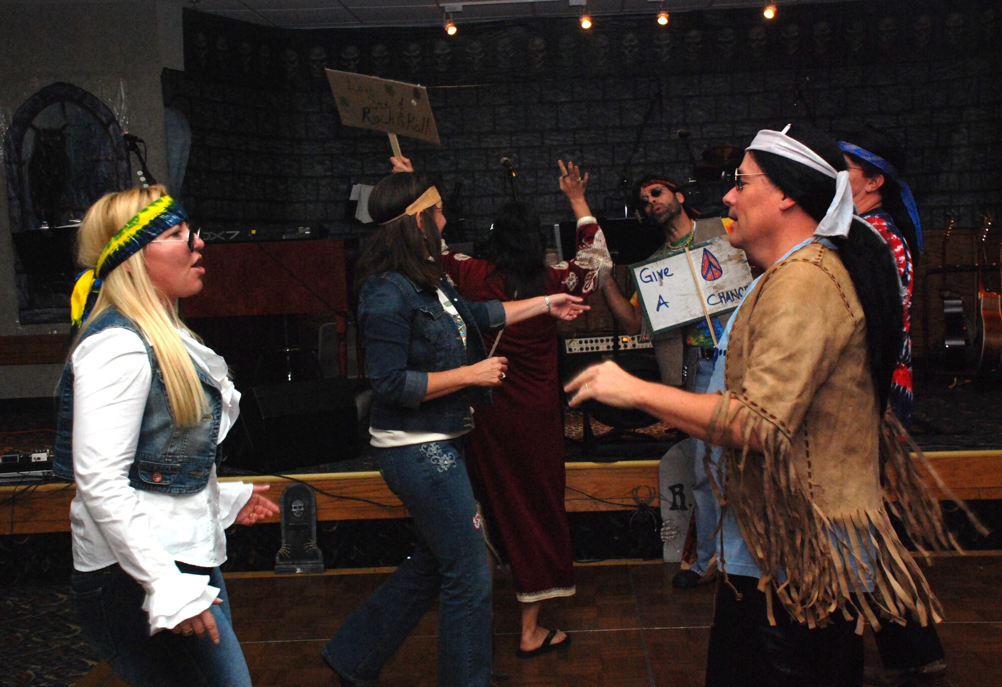 Senior Master Sgt. Chris Sheppard, fuels flight superintendent with the 364th Training Squadron, dances with his wife Master Sgt. Petra Sheppard, superintendent of the group commander support staff with the 82nd Training Group, while their fellow "hippies" at the Sheppard Club's Halloween party Oct. 27. (U.S. Air Force photo/Airman 1st Class Jacob Corbin)