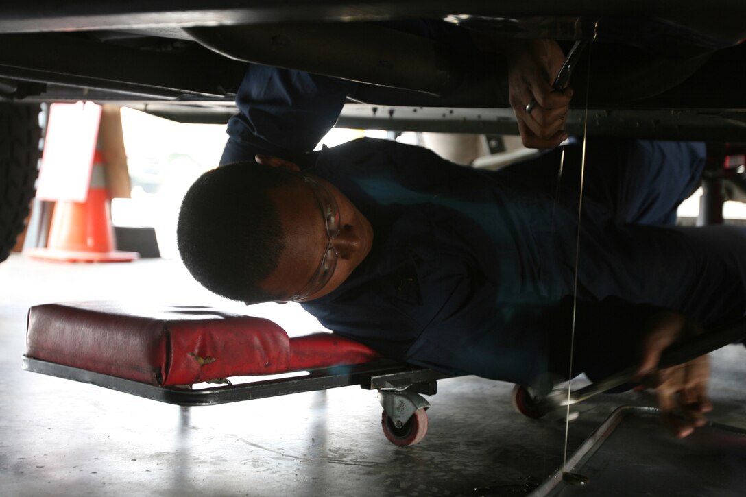 MARINE CORPS AIR STATION MIRAMAR, Calif. - Lance Cpl. John Sai, a native of Phoenix, Ariz., a mechanic with Marine Wing Support Squadron 373, removes the oil plug of a humvee in order to change the oil. Sai is one of several mechanics who have worked to raise the vehicle availability rating of the squadron. (U.S. Marine Corps photo by Lance Cpl. Austin Goacher) (Released).