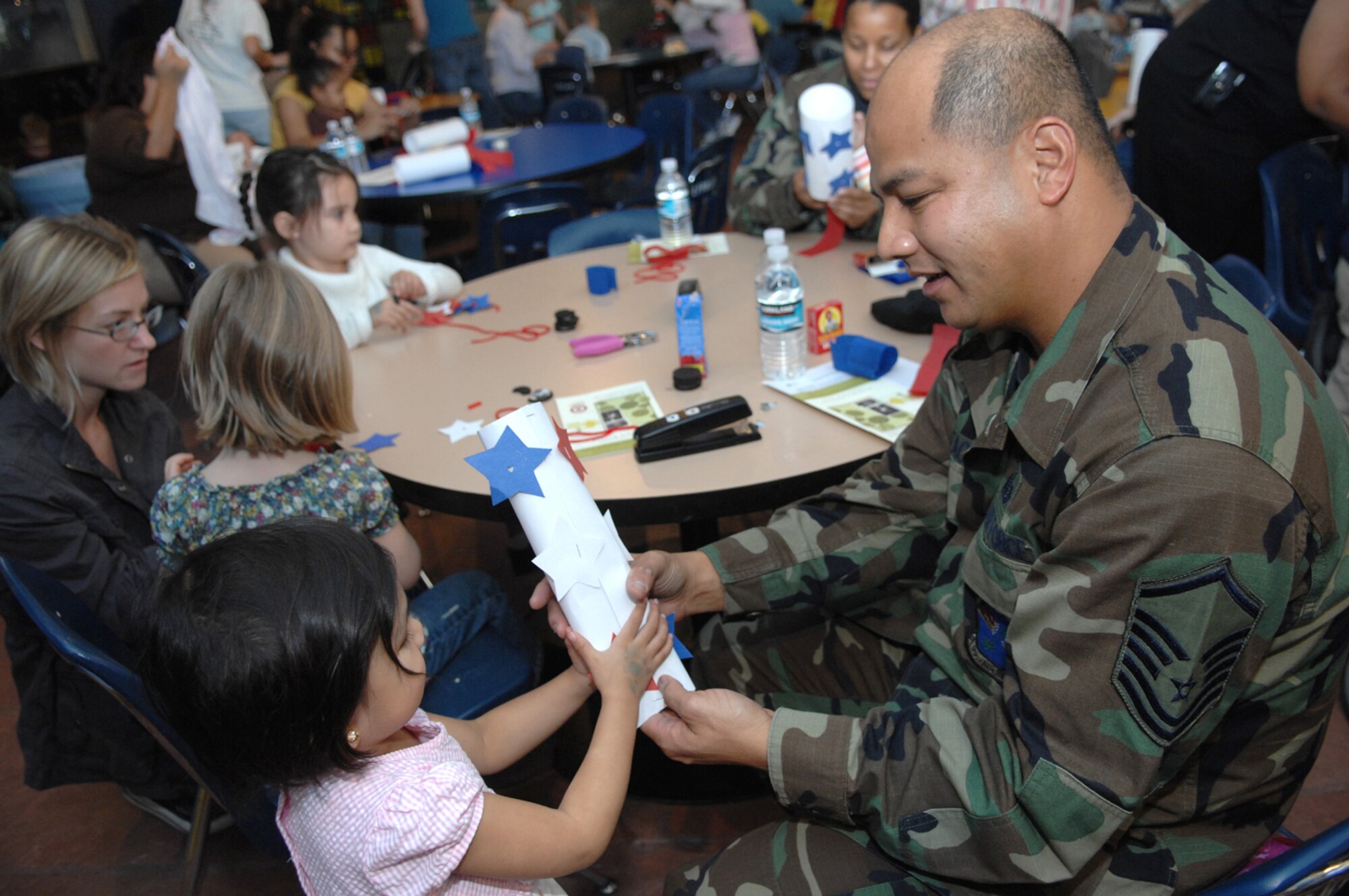 Master Sgt. Meril "Bob" Monteagudo, 99th MSS, Family Readiness NCO and daughter Kaelynn Monteagudo, 3, create red, white and blue "wind socks" Nov. 2 at the Lied Discovery Childrens Museum in Las Vegas.  more than 25 families attended the event at the museum, which offered military families a discounted admission price, in honor of military family month that is being celebrated in Nov. (U.S. Air Force photo by Senior Airman Larry Reid jr.)