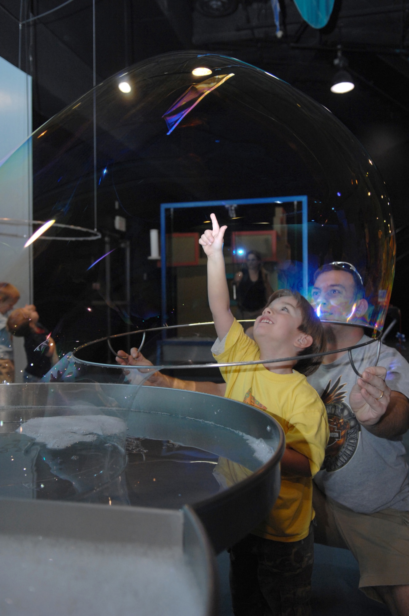 Nathen Going, 4, is encased by a giant bubble by his father, U.S. Air Force Staff Sergeant Wesley Going, 57th EMS Nov.  2 at the Lied Discovery Childrens Museum. The museum attractions are geared more towards infant age to 5 year-old children and aim to increase critical thinking and team building between kids their age. (U.S. Air Force photo by Senior Airman Larry Reid Jr.)