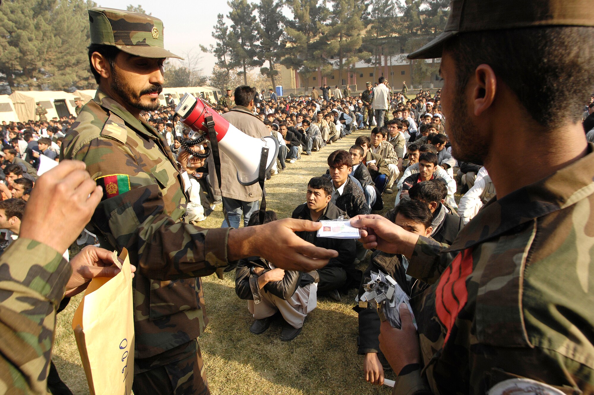 Afghan National Army soldiers and academy cadets hand out identification cards to perspective cadets at the ANA Academy, Kabul, Afghanistan, Oct. 25. There are more than 1,800 perspective cadets here, all hoping to be one of the approximately 300 chosen for the new freshman class. (U.S. Air Force photo/Staff Sgt. Brian Ferguson) 