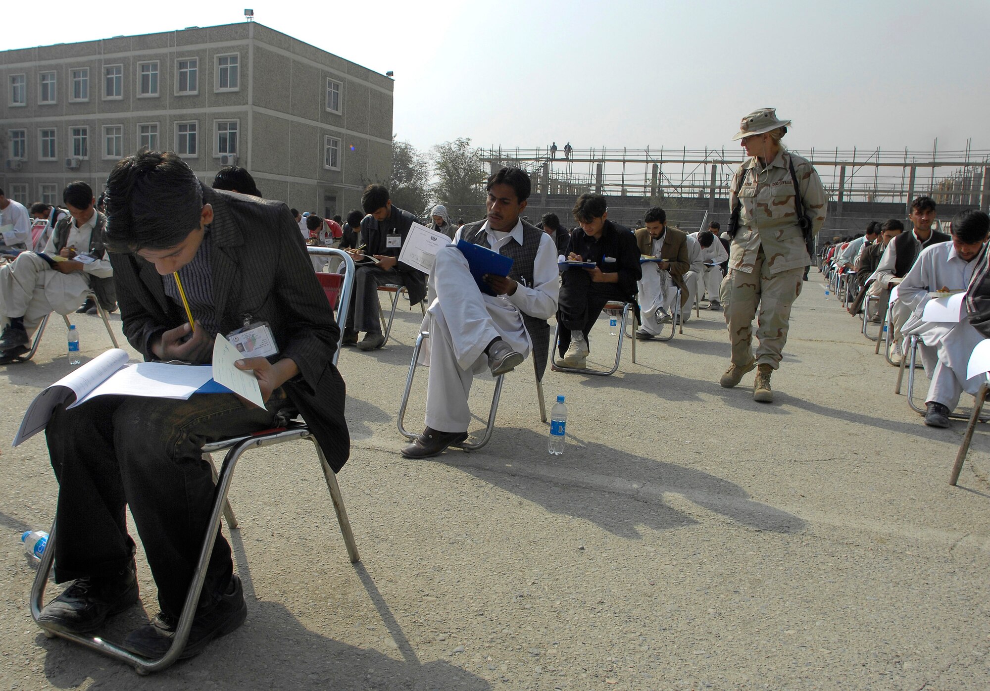 Department of Defense Civilian Sally Carter walks through the isles as perspective cadets take the Afghan college entrance exam for the Afghan National Army Academy, Kabul, Afghanistan, Oct. 25. There are more than 1,800 perspective cadets here, all hoping to be one of the approximately 300 chosen for the new freshman class. The exam makes up 80 percent of their final admissions score. Ms. Carter is the english language training coordinator for Afghanistan. (U.S. Air Force photo/Staff Sgt. Brian Ferguson) 

