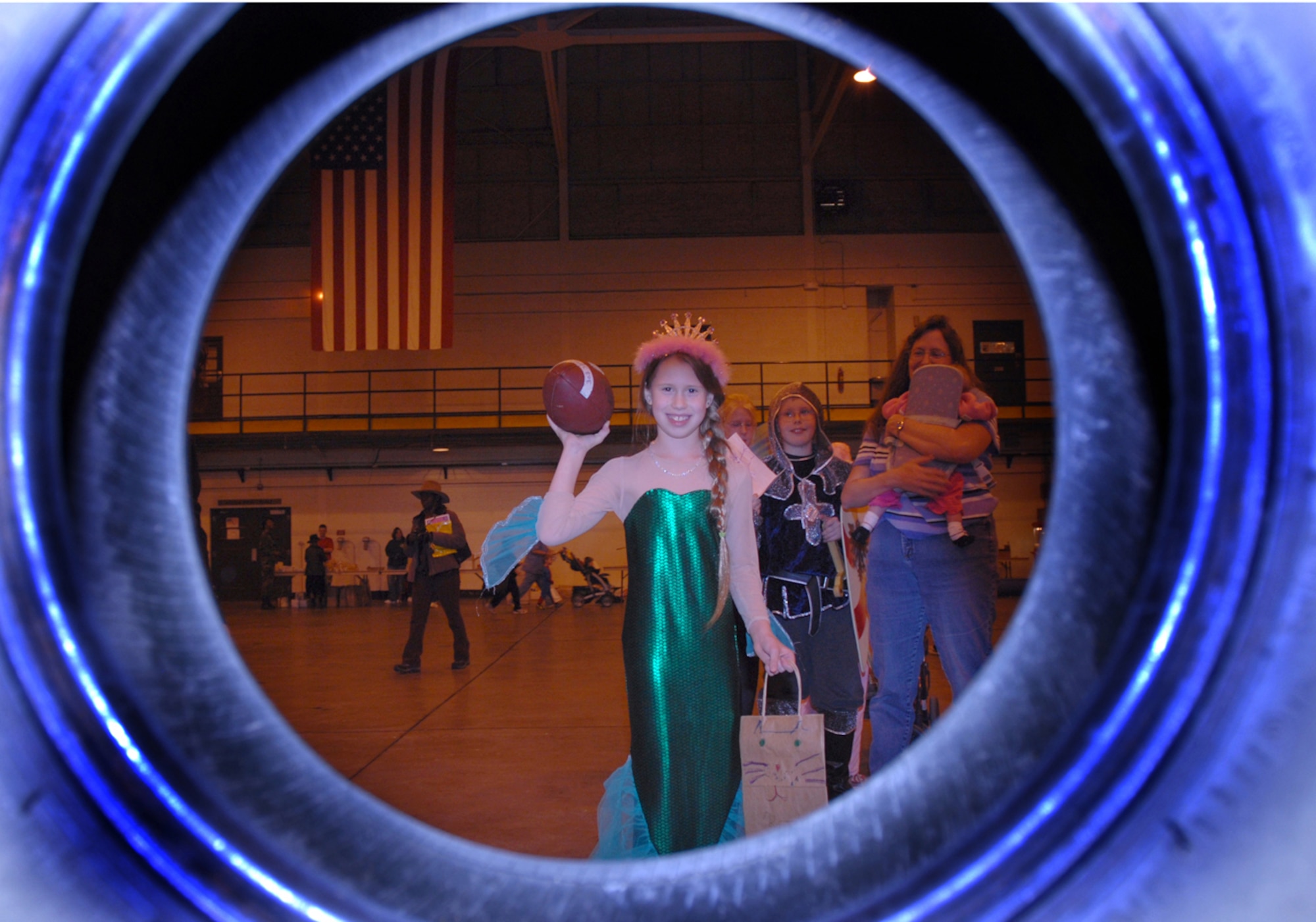 BUCKLEY AIR FORCE BASE, Colo -- Kate Walsh throws a football through a tire at the Buckley Chapel's Fall Festival in Hangar 909 Oct. 31. (U.S. Air Force photo by Airman 1st Class Michelle Cross Furtado)