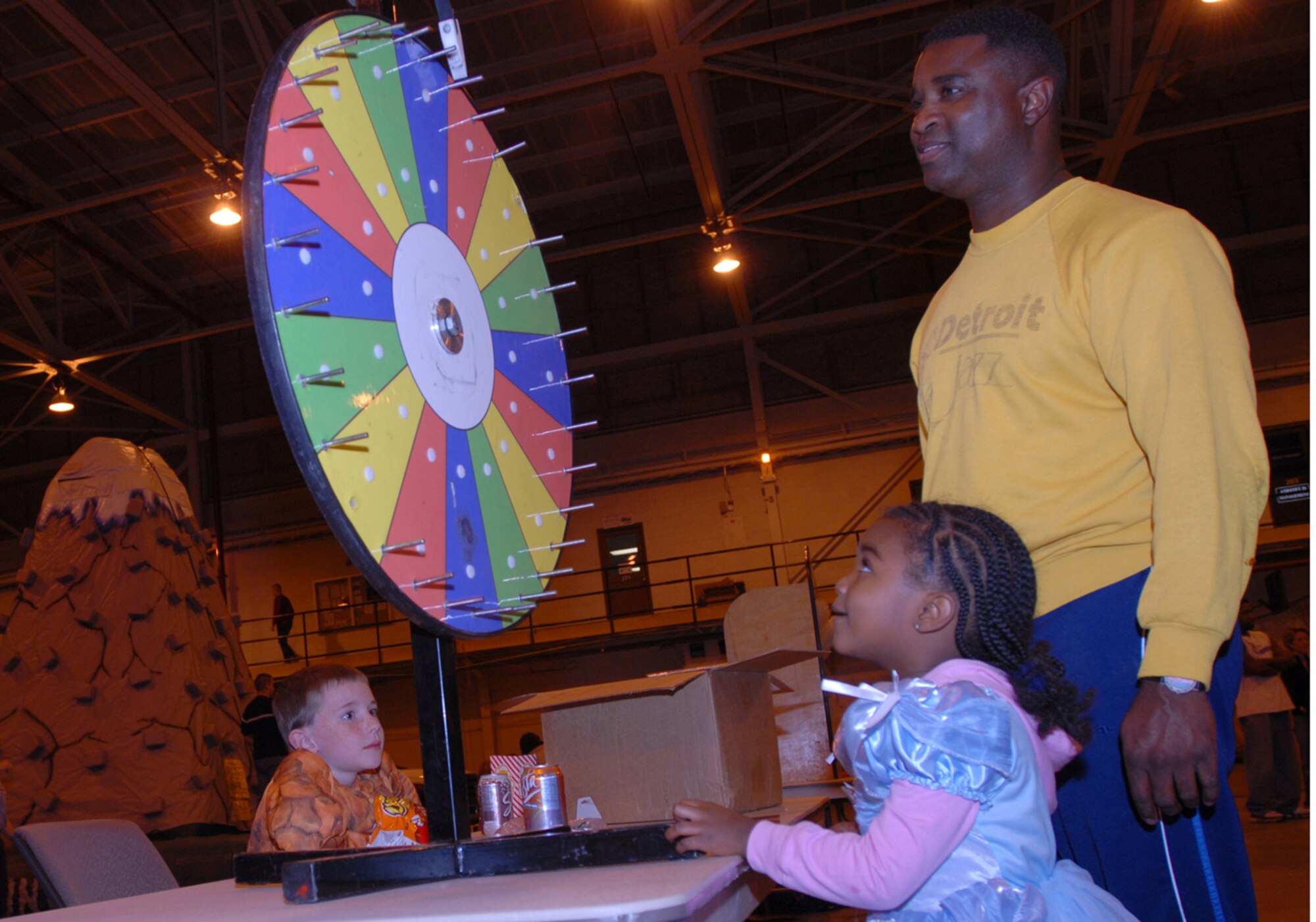 BUCKLEY AIR FORCE BASE, Colo. -- Maya Williams, with her father, 460th Mission Support Group's Chief Master Sgt. Gregory Williams, watches the prize wheel spin to find out what she won during the Fall Festival at Hangar 909 on Oct. 31. The fall festival was organized by Buckley Chapel. (U.S. Air Force Photo by Airman 1st Class Michelle L. Cross Furtado)