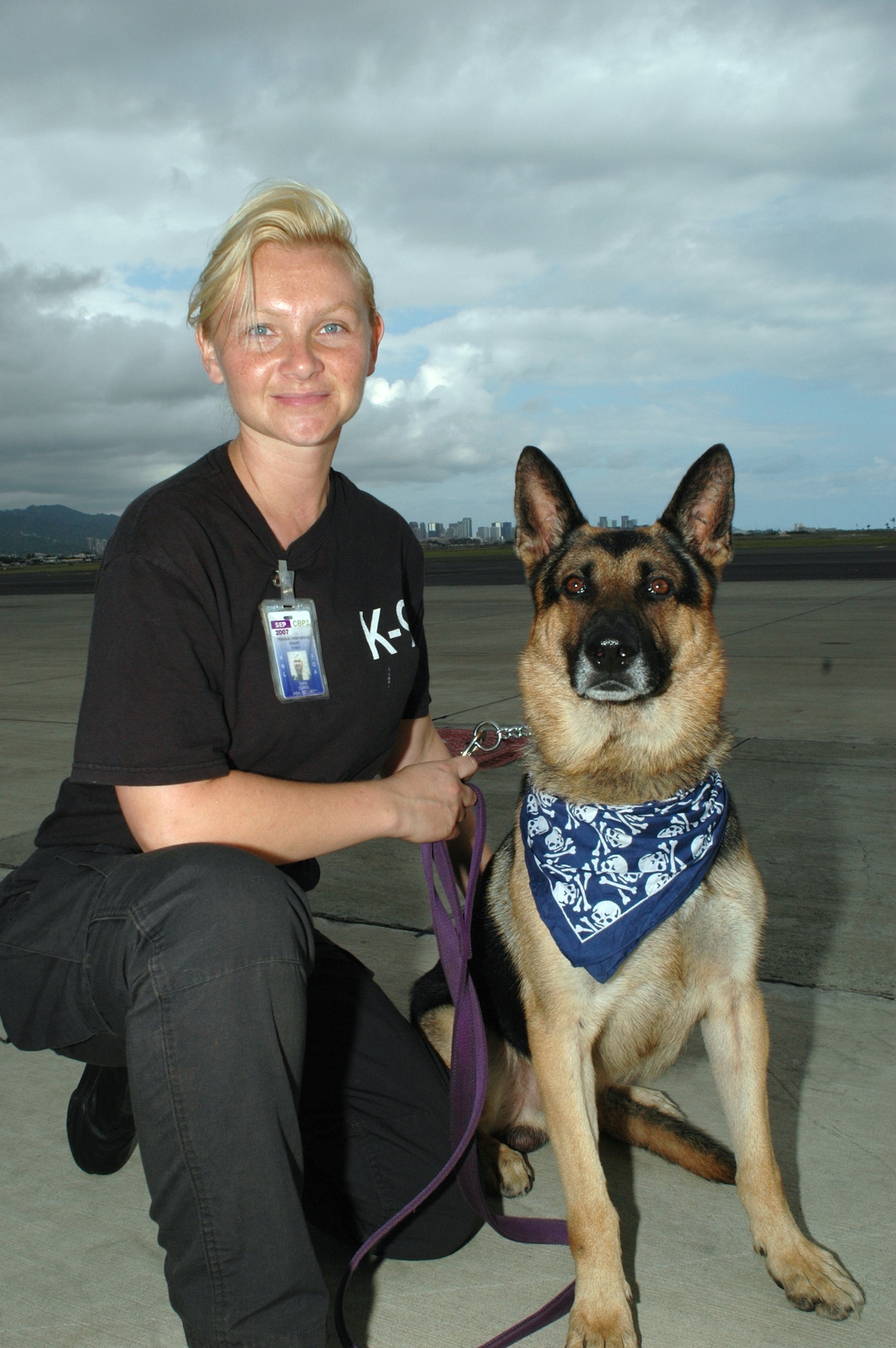 Master Sgt. Tara Corse, 48th Aerial Port Squadron, in her civilian job, patrols the flightline with her partner Terry at Honolulu International Airport.  Sergeant Corse is a Explosives Detection Dog Handler with the Transportation Security Administration. Air Force Photo/Master Sgt. Daniel Nathaniel