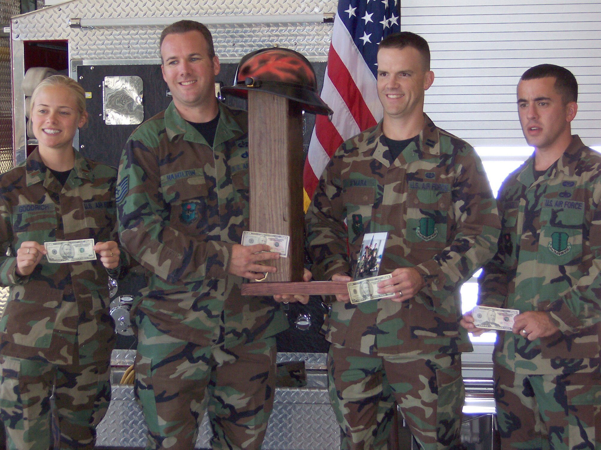 (From left to right): Second Lt. Karissa Goodrich, Tech. Sgt. Thomas Hamilton, Capt. Mike O'Mara and Tech. Sgt. Edward Struckel, members of the 17th Training Wing legal office 2007 Firefighter Obstacle Course Challenge team, pose for a group photo during a trophy presentation ceremony inside the Goodfellow Air Force Base Fire Department fire house Oct. 12. The team took first place in the challenge with a time of 3 minutes and 3 seconds. The team won $200 for finishing first. (U.S. Air Force photo by Assistant Fire Chief Richard Alter.)