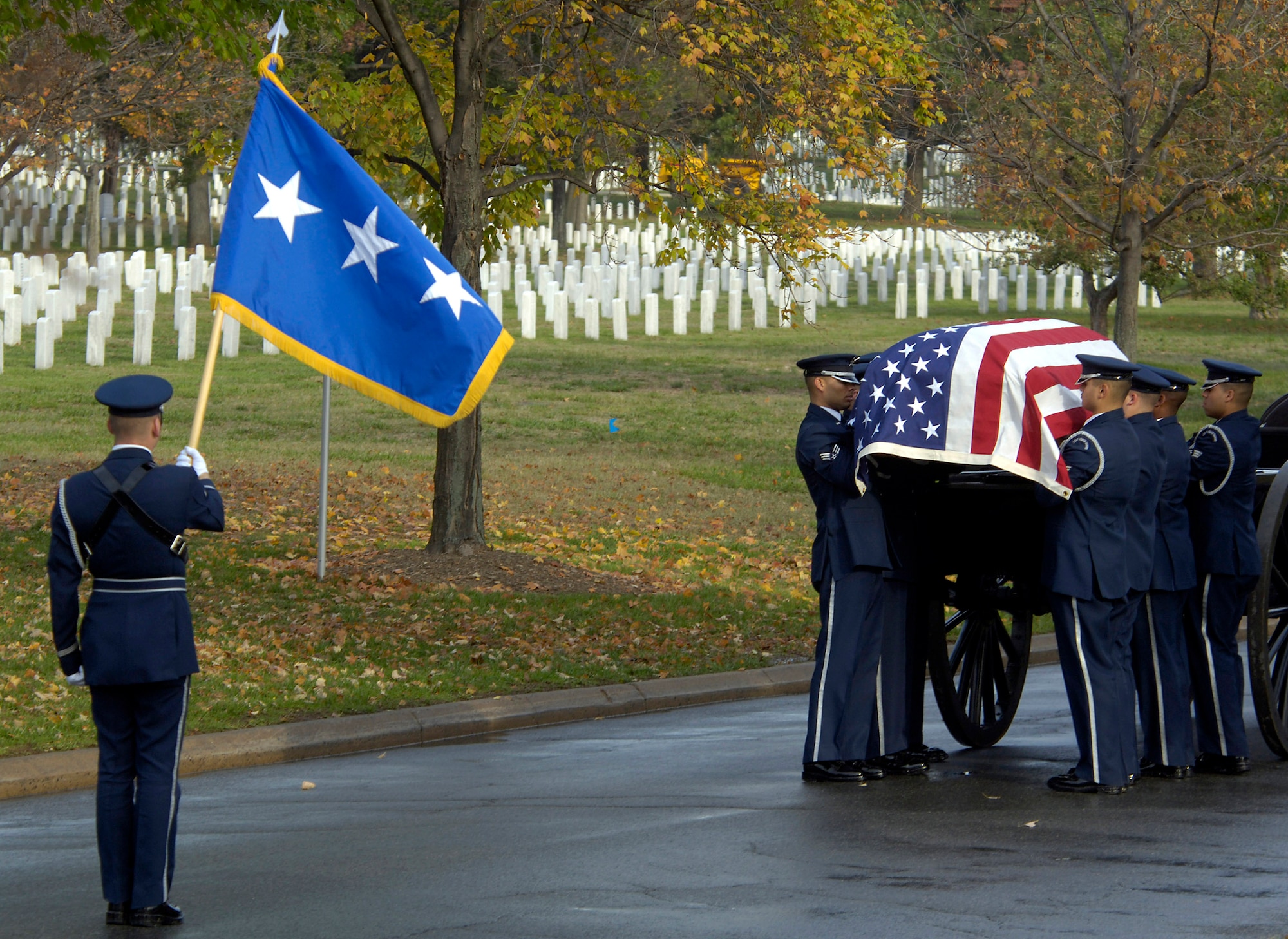 Airman 1st Class Michael Gibson (left) bears the personal colors as pall bearers lift the casket from a caisson during a military honors funeral ceremony Nov. 1 for retired Lt. Gen. Marvin McNickle at Arlington National Cemetery, Washington, D.C.  Airman Gibson is a Air Force Honor Guardsman.  (U.S. Air Force photo/Master Sgt. Jim Varhegyi)