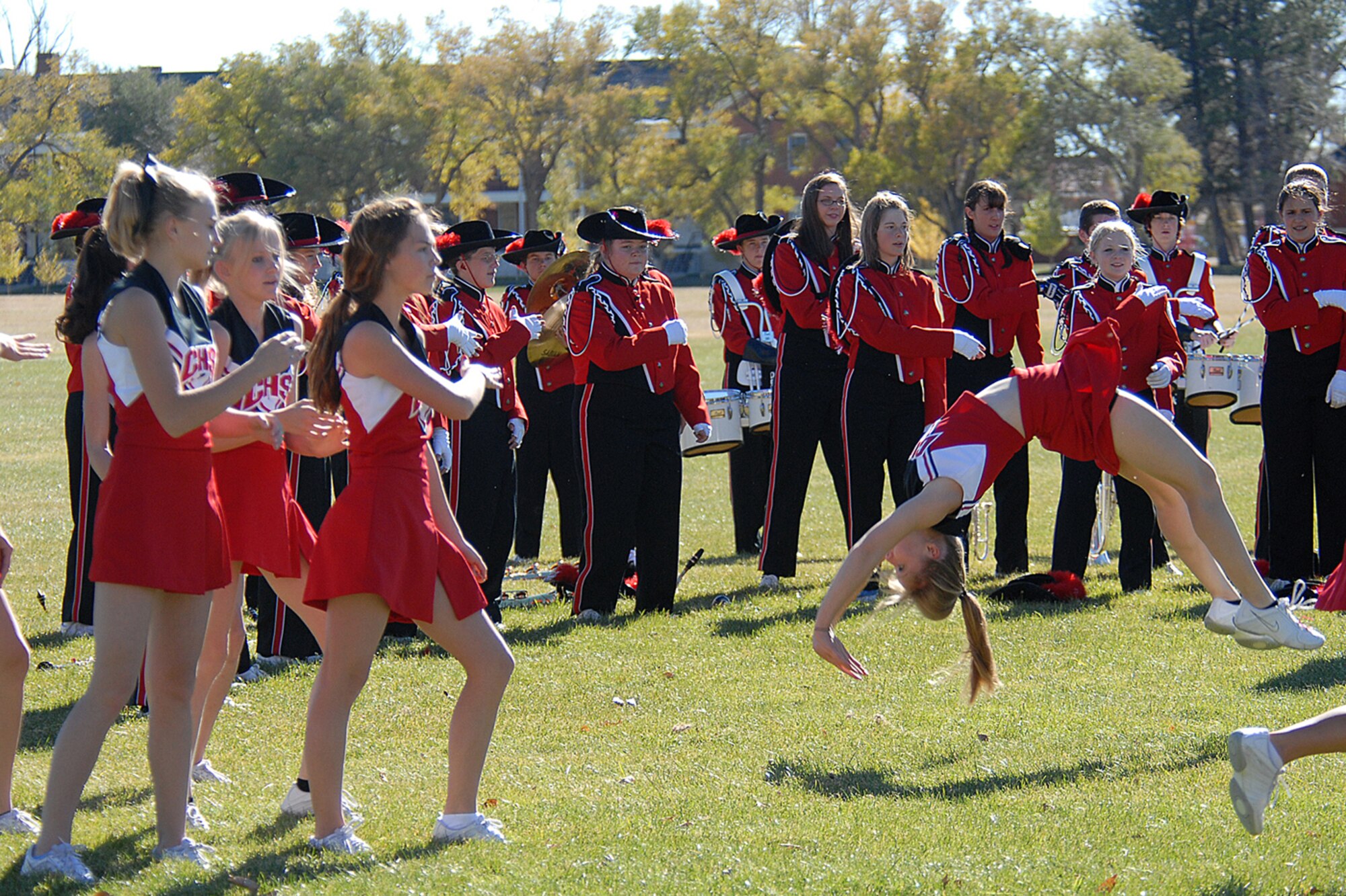 Jenna Farrester, a 12th grader at Cheyenne Central High School, completes a back-flip during the Red Ribbon Week parade. The Cheyenne Central High School cheerleaders and band performed during the parade.