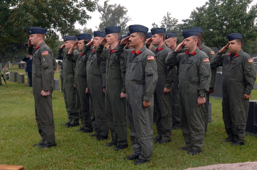 Members of the 20th Special Operations Squadron render salutes as the Hurlburt Field Honor Guard folds the flag from retired Col. William Tackas' casket during the graveside ceremony at Beal Memorial Cemetary in Fort Walton Beach Oct. 22. Colonel Tackas was the first commander of the 20th SOS. (U.S. Air Force photo by Senior Airman Ali Flisek) 